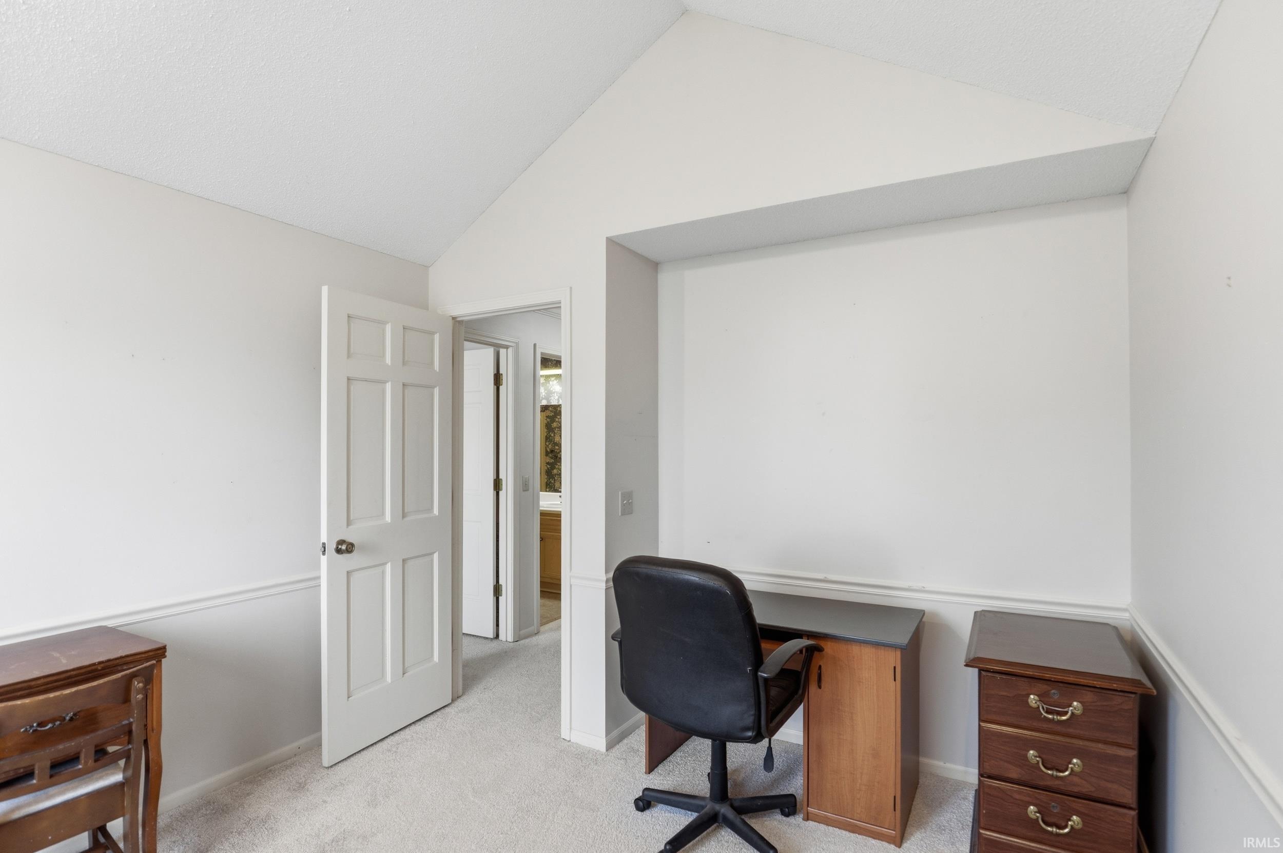 Office featuring lofted ceiling and light colored carpet