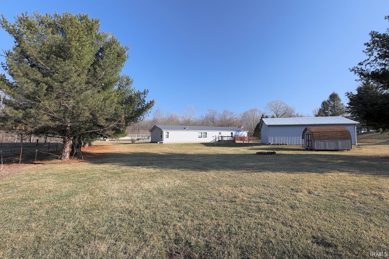 View of yard featuring an outdoor fire pit and a shed