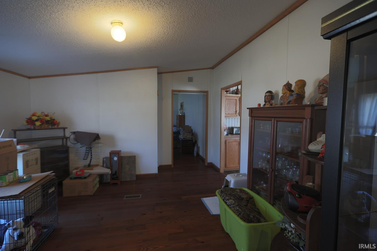 Dining area featuring dark wood-style flooring and crown molding