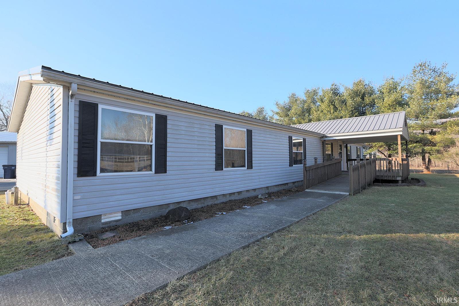 View of front facade featuring crawl space, a metal roof, and a front lawn