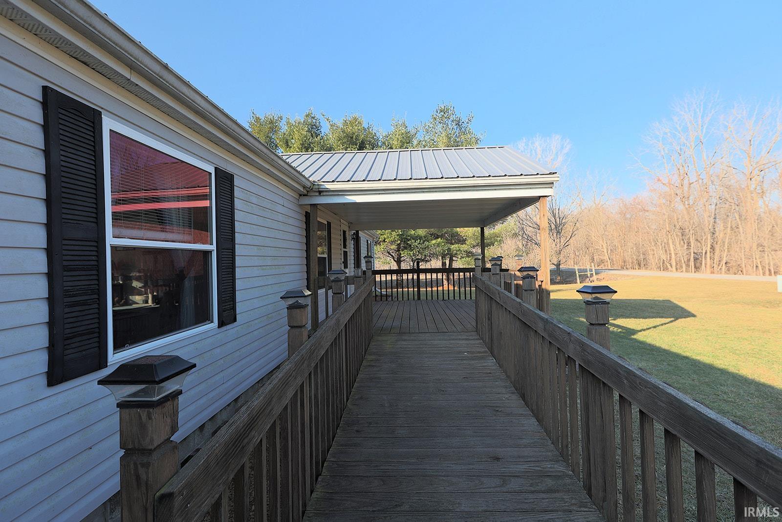 Wooden porch featuring a lawn