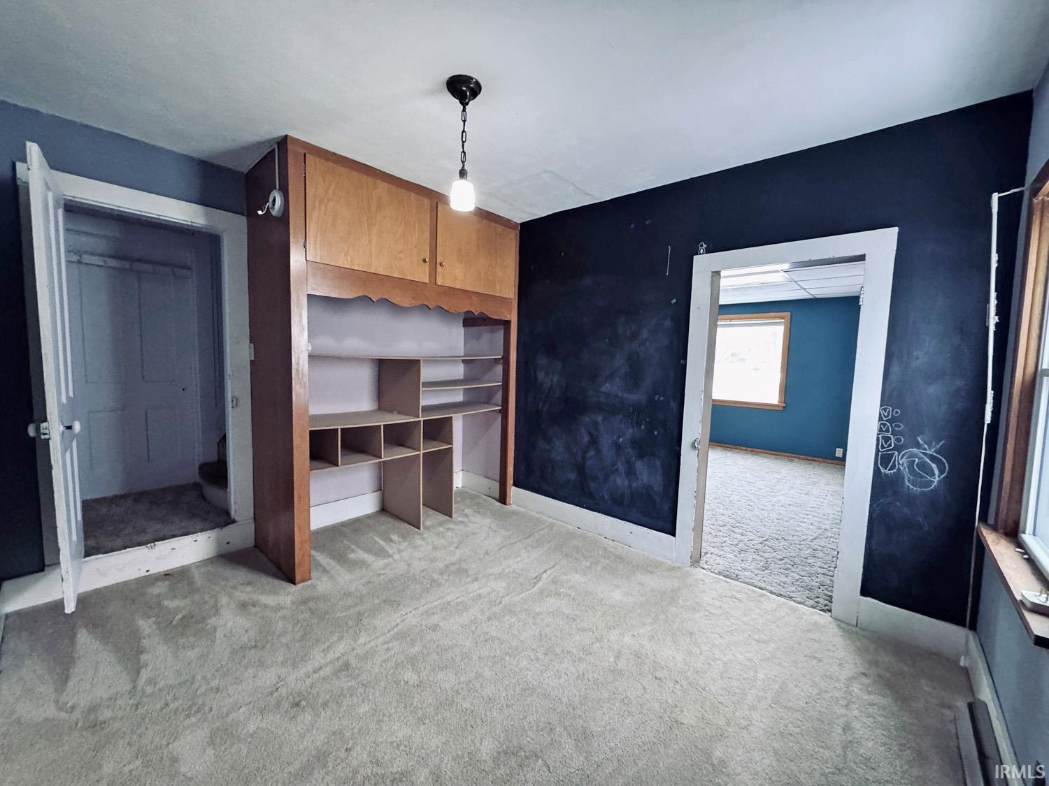 Unfurnished bedroom with light carpet and baseboards