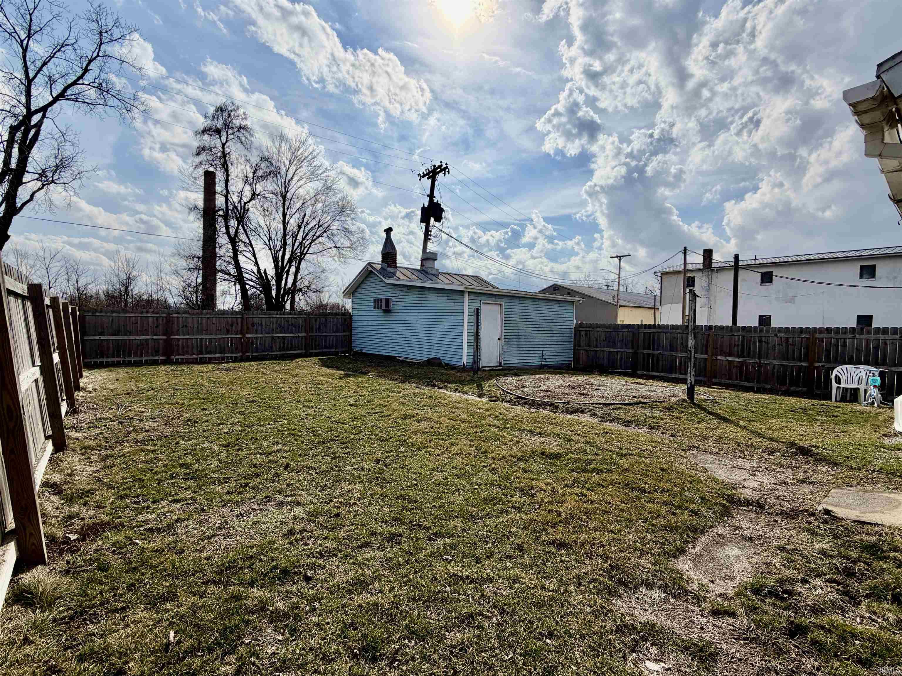 Fenced backyard with an outdoor structure