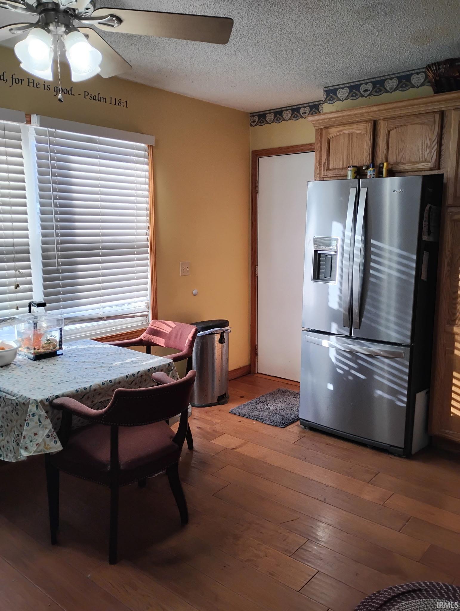 Dining space featuring ceiling fan, a textured ceiling, and dark wood finished floors