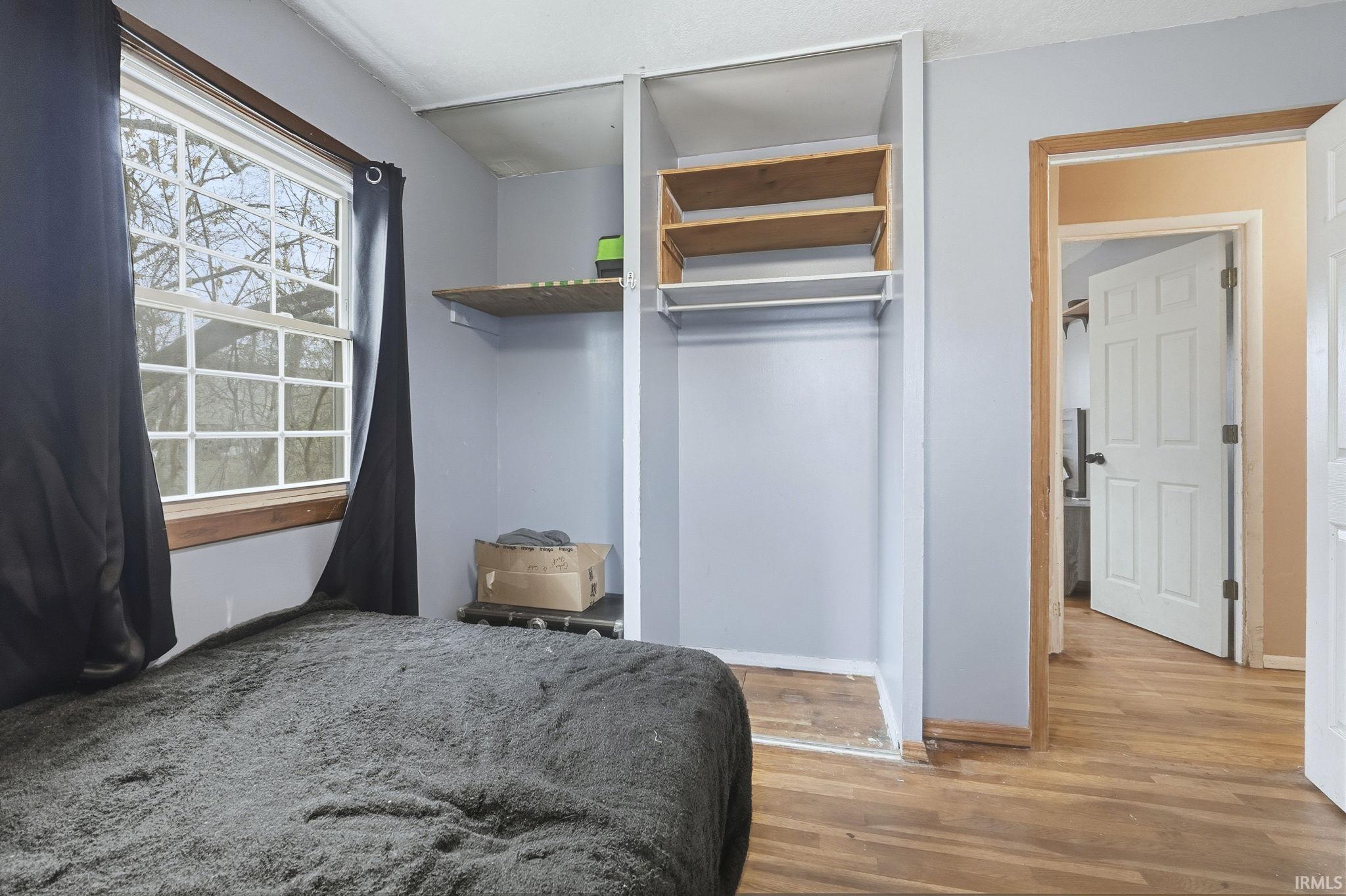 Bedroom with light wood finished floors and baseboards