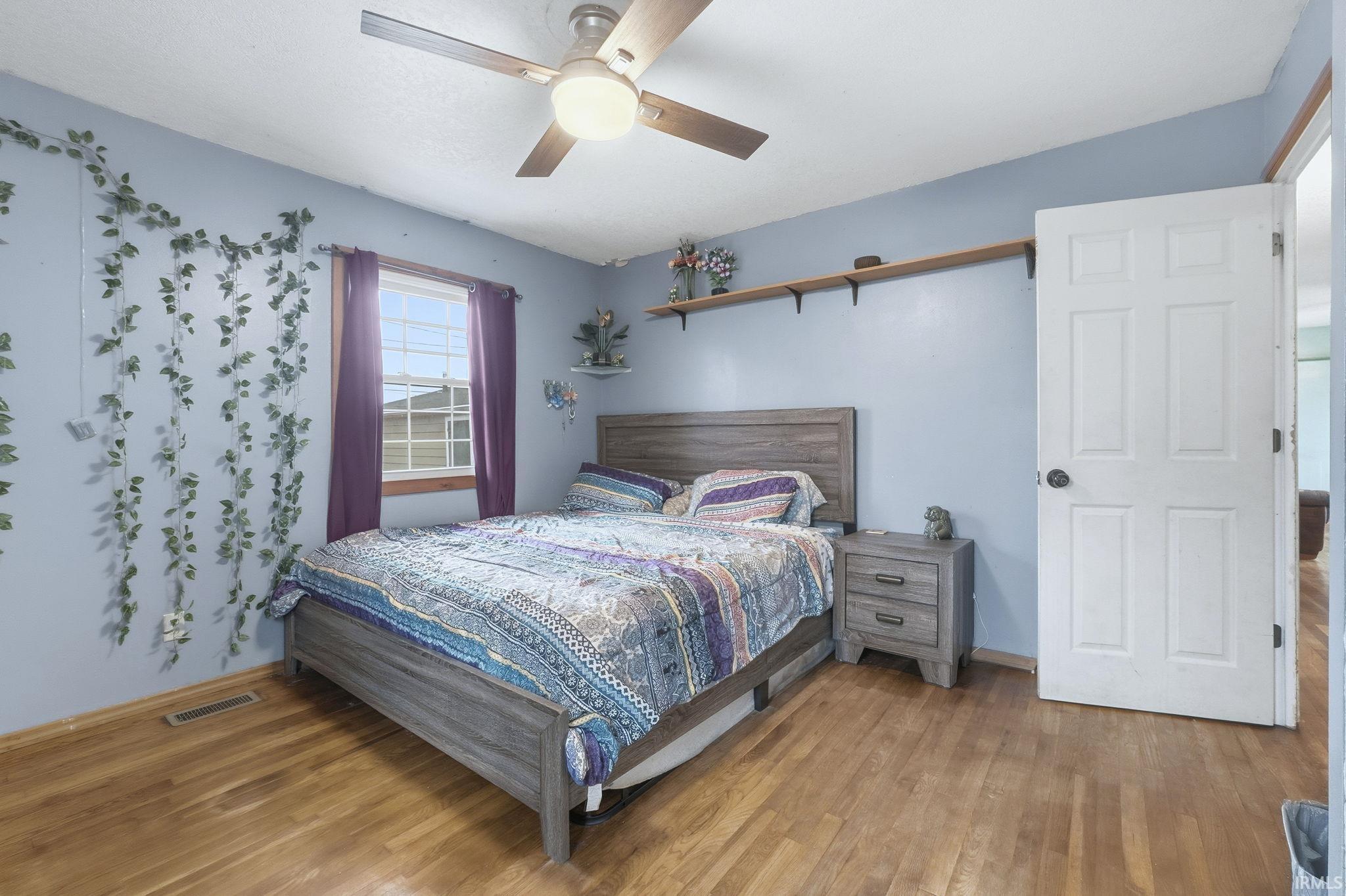 Bedroom with wood finished floors and a ceiling fan