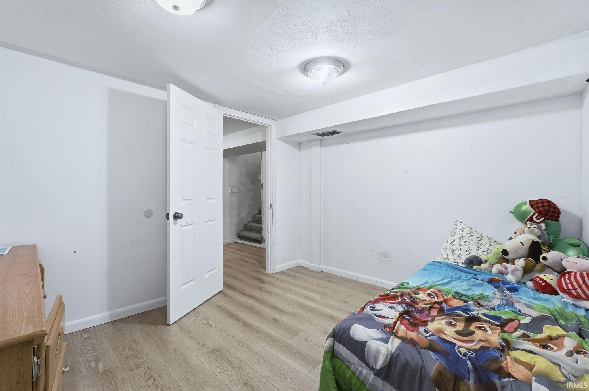 Bedroom with light wood-style floors and baseboards