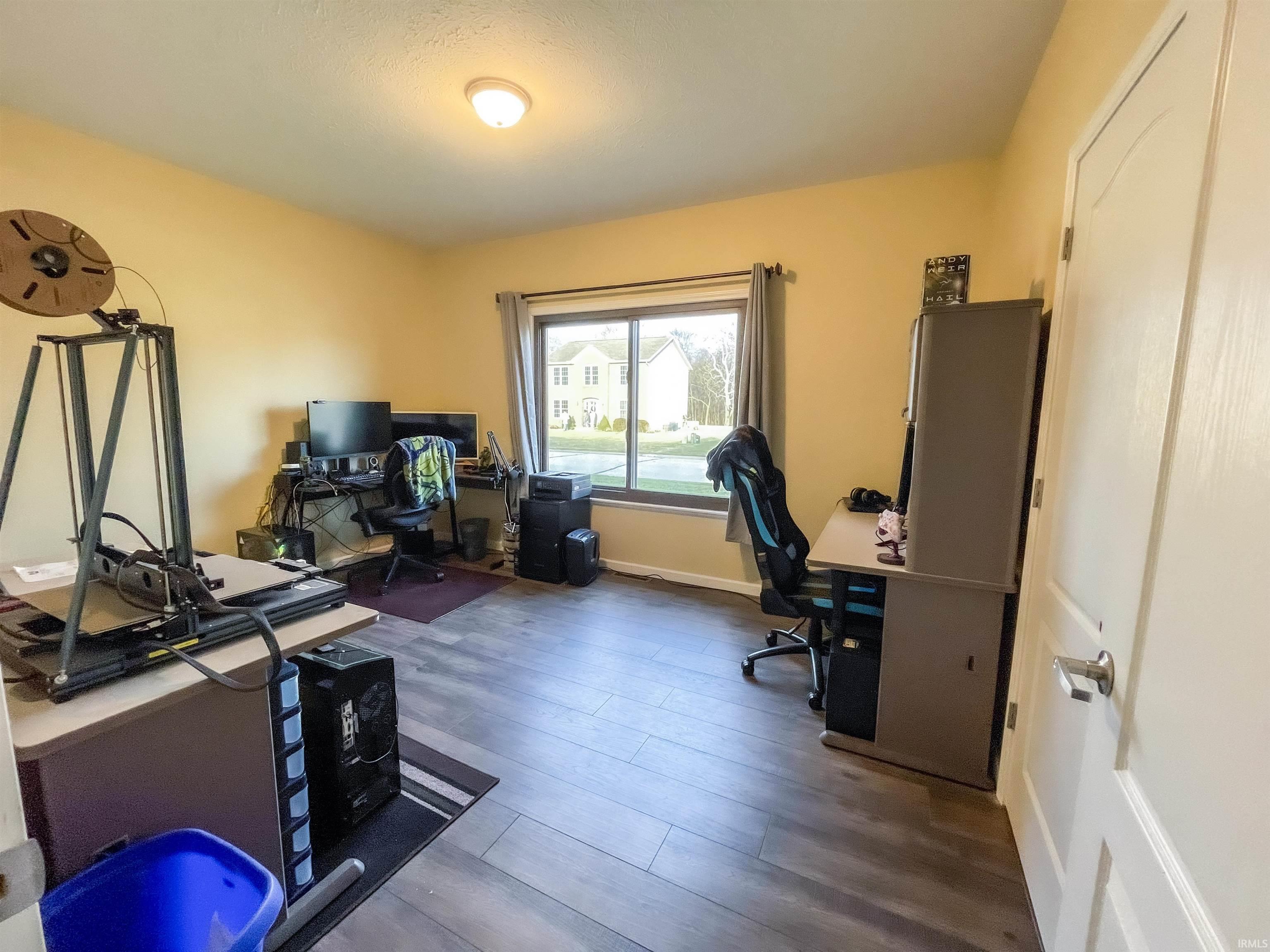 Home office with dark wood-style floors and baseboards