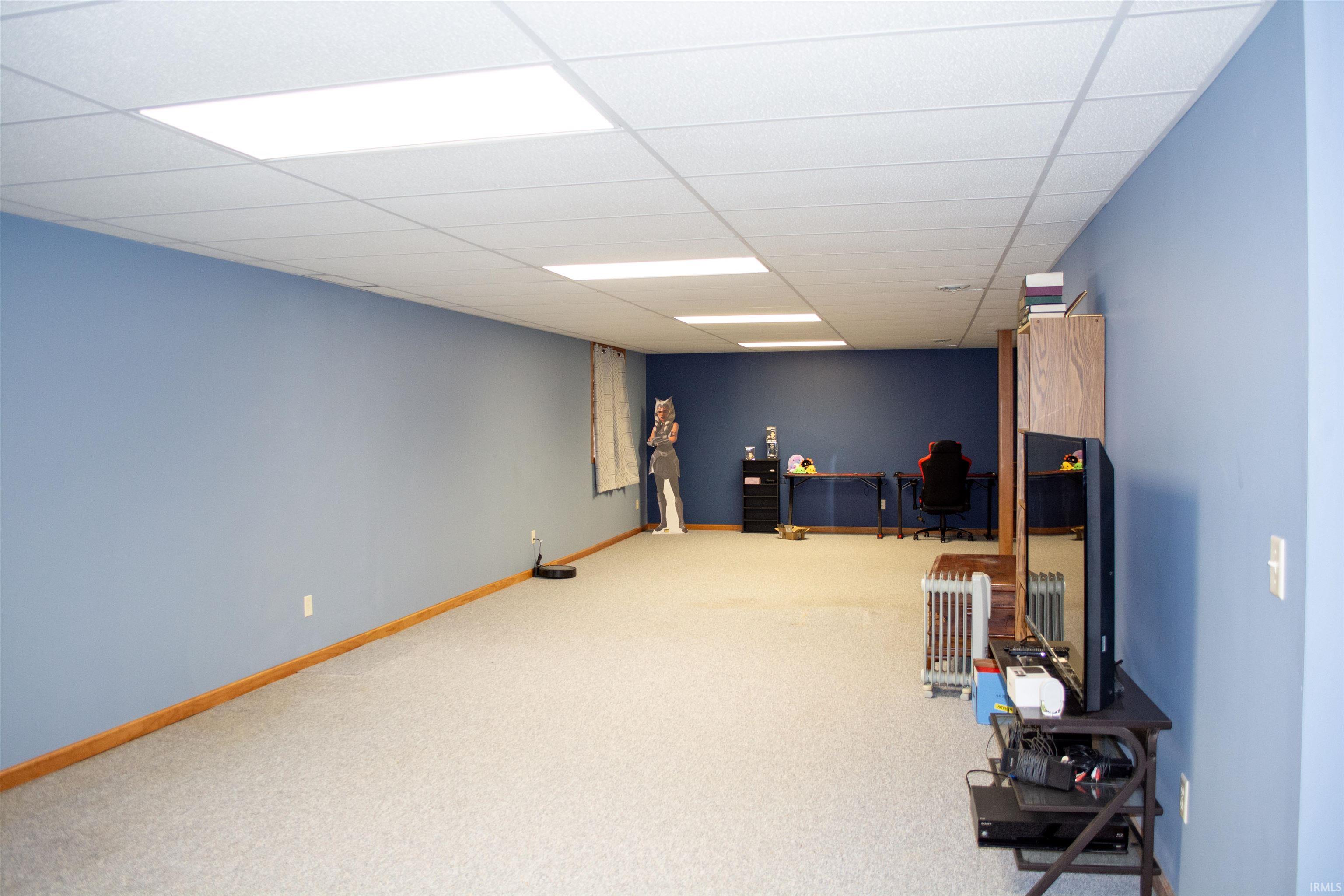 Rec room with a drop ceiling and light carpet