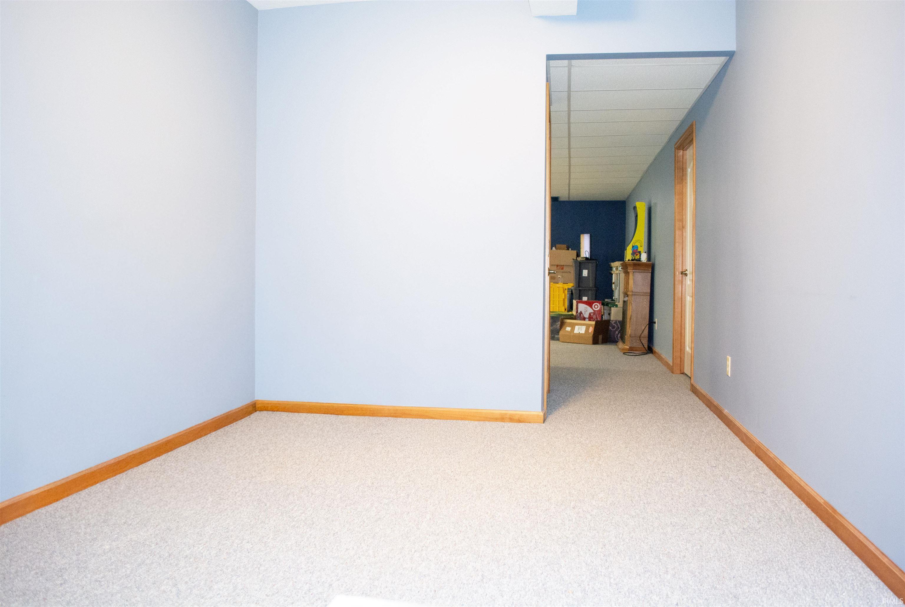 Empty room featuring light colored carpet and baseboards