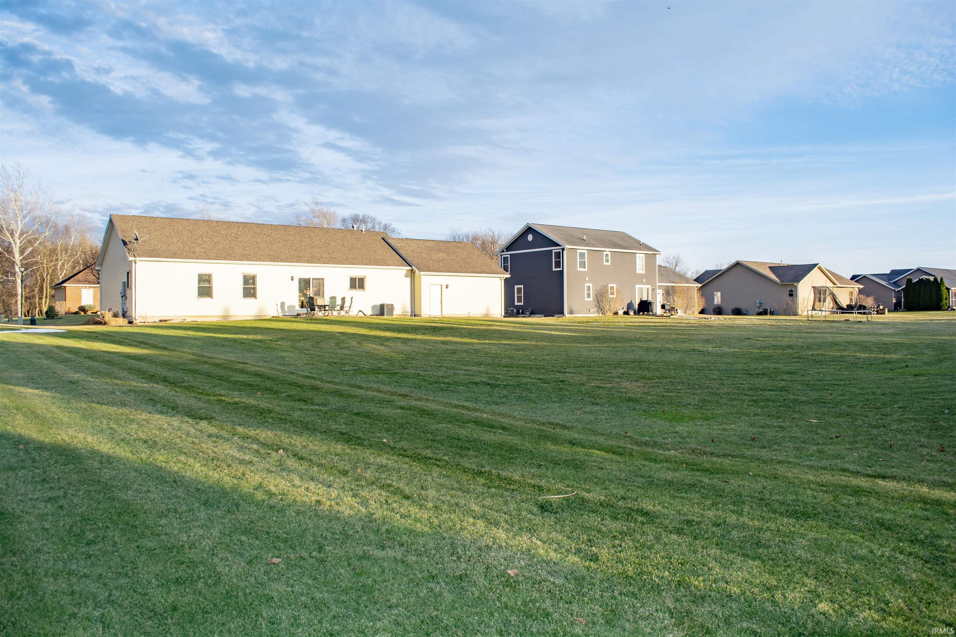 Rear view of property with a yard and a residential view