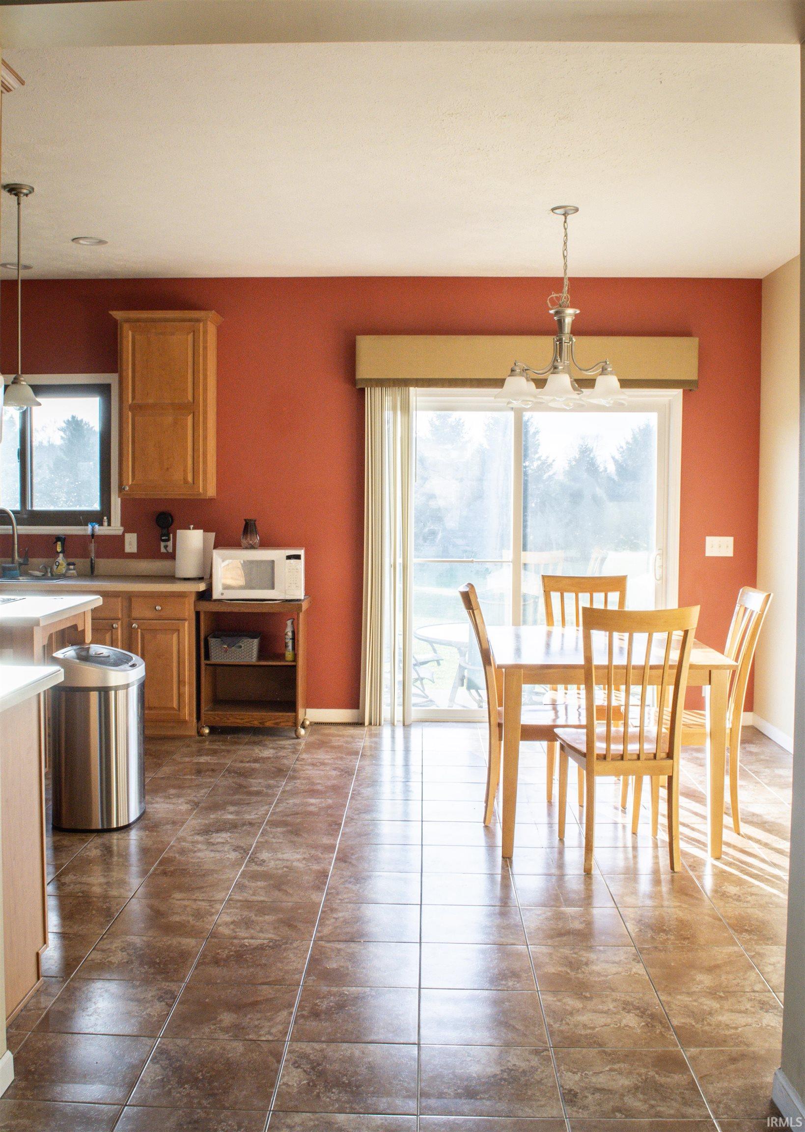 Dining space with hanging lights and dark tile patterned floors