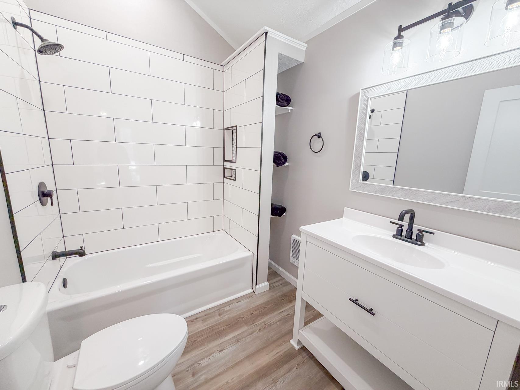 Full bathroom featuring vanity, light wood-style floors, and shower / bath combination