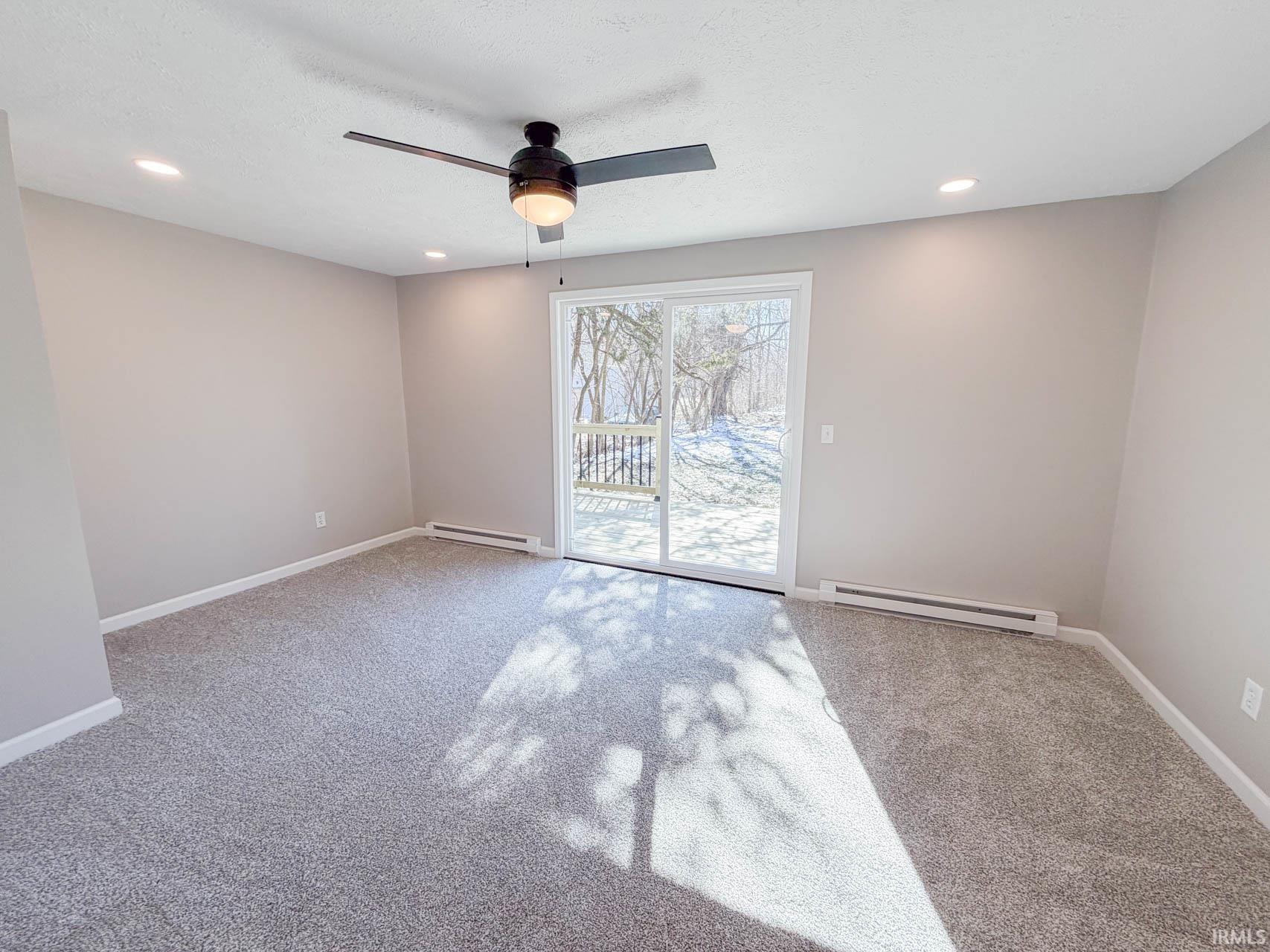 Spare room featuring baseboard heating, recessed lighting, ceiling fan, and light carpet