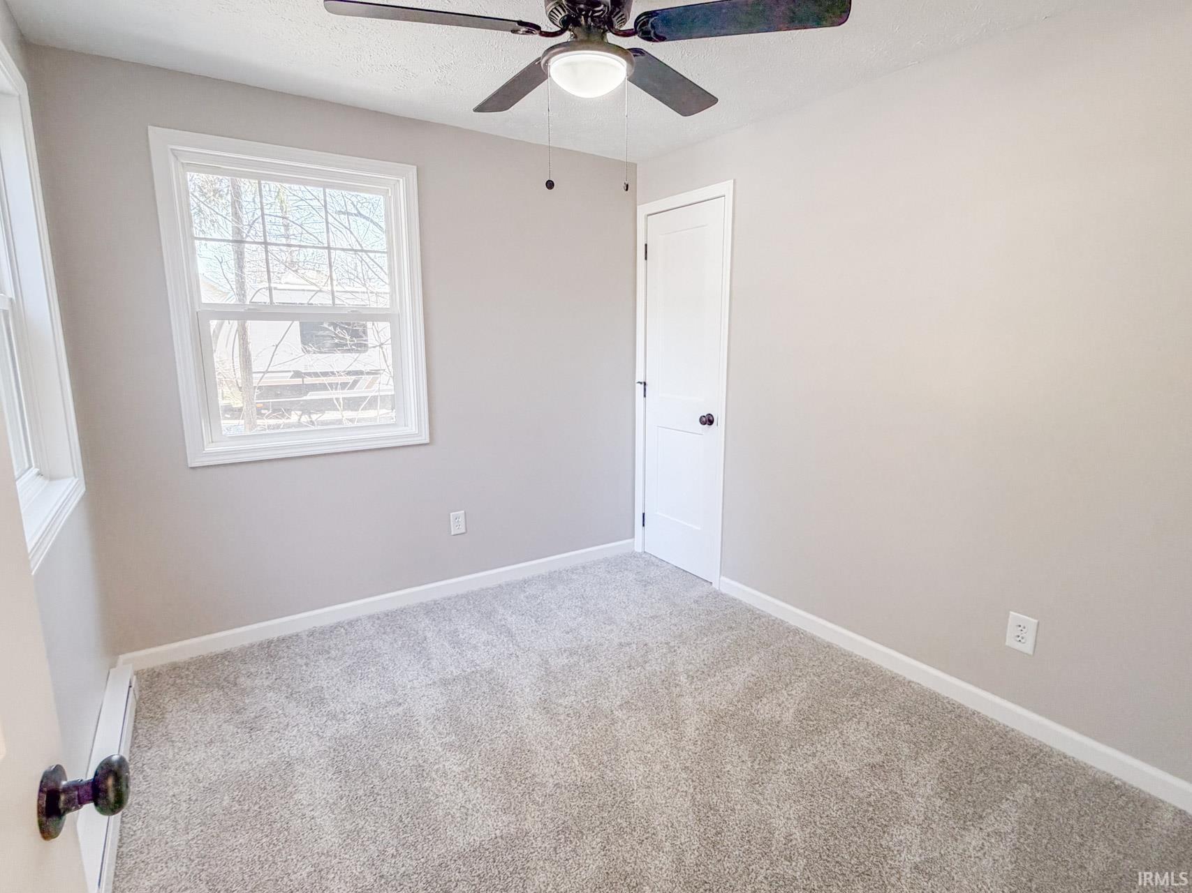 Unfurnished room featuring light carpet and ceiling fan