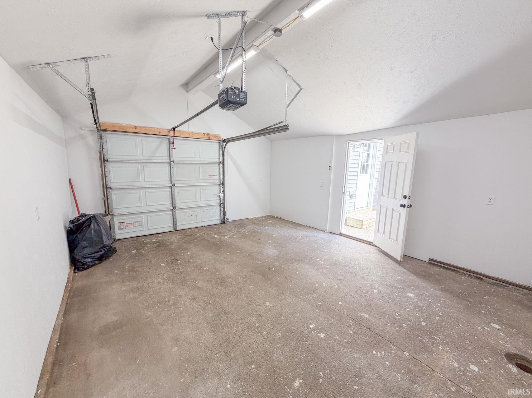 Garage with baseboards and a garage door opener