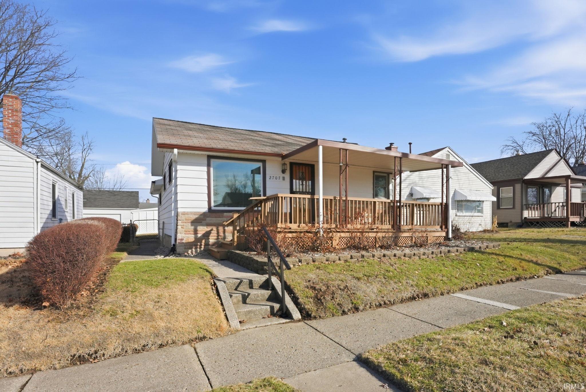 View of front of property featuring a front lawn and covered porch