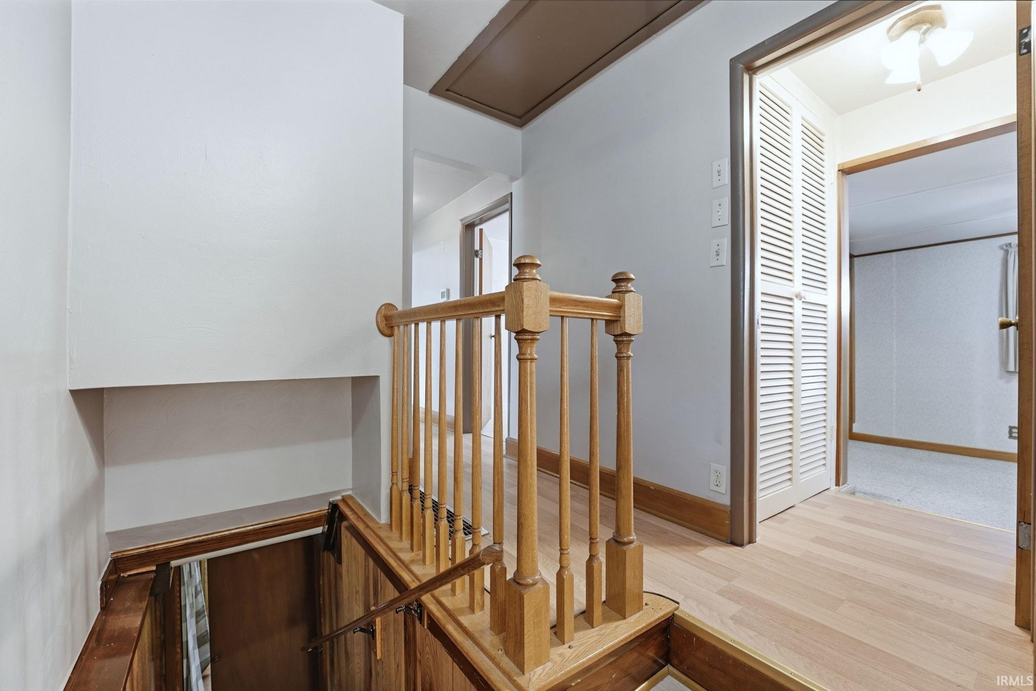 Stairs with wood finished floors and baseboards