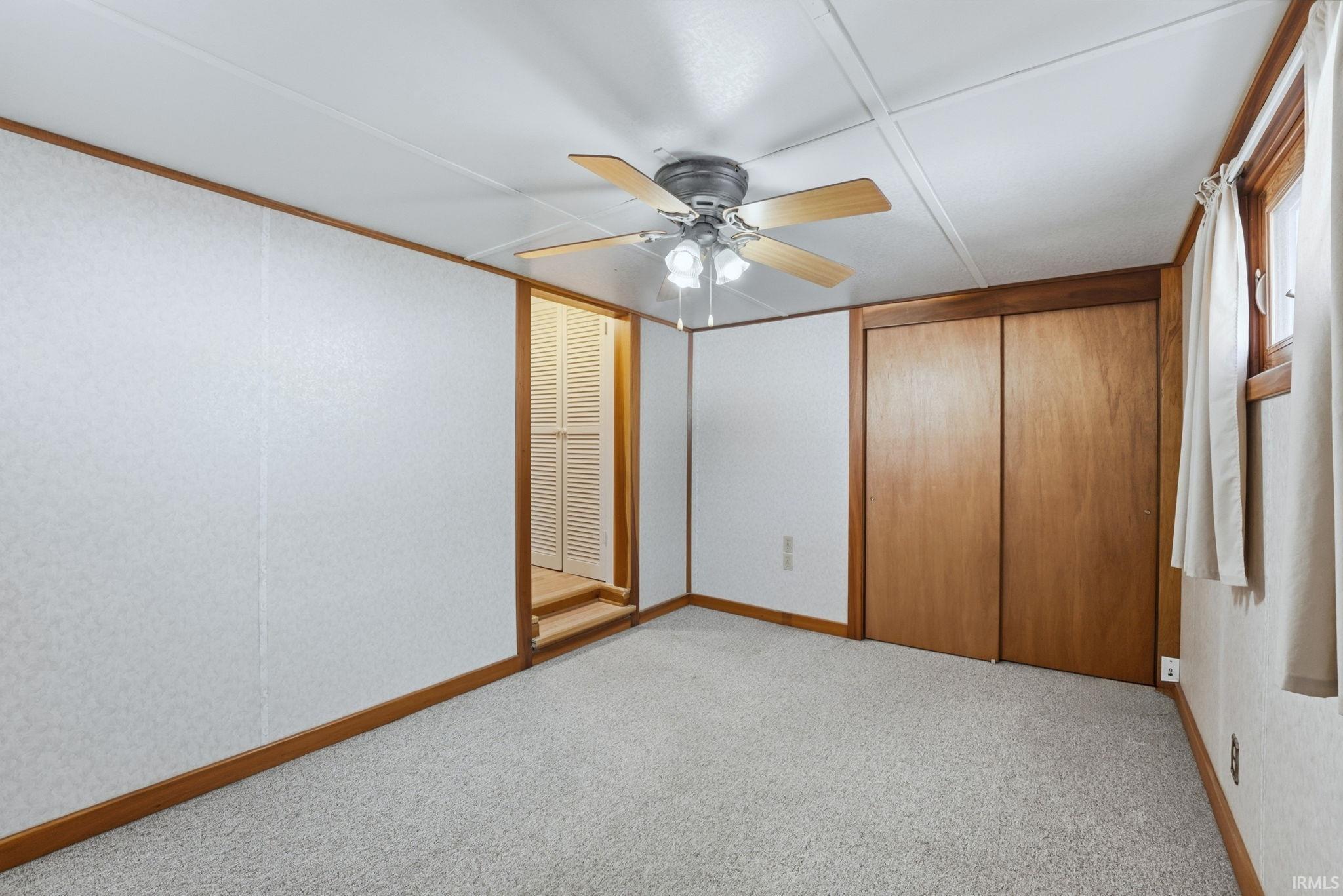 Unfurnished bedroom with a closet, ceiling fan, and light colored carpet