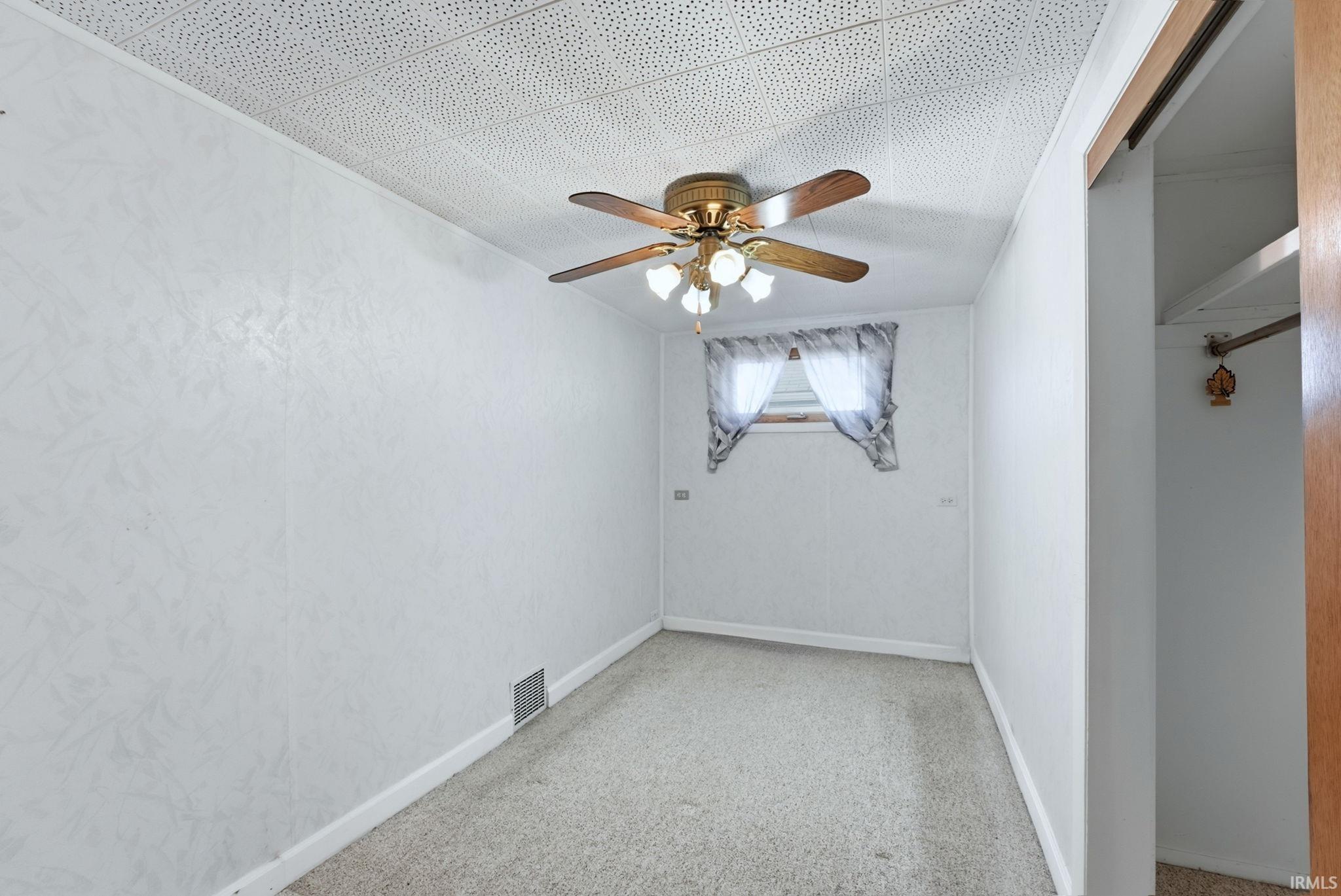 Empty room featuring ceiling fan and baseboards