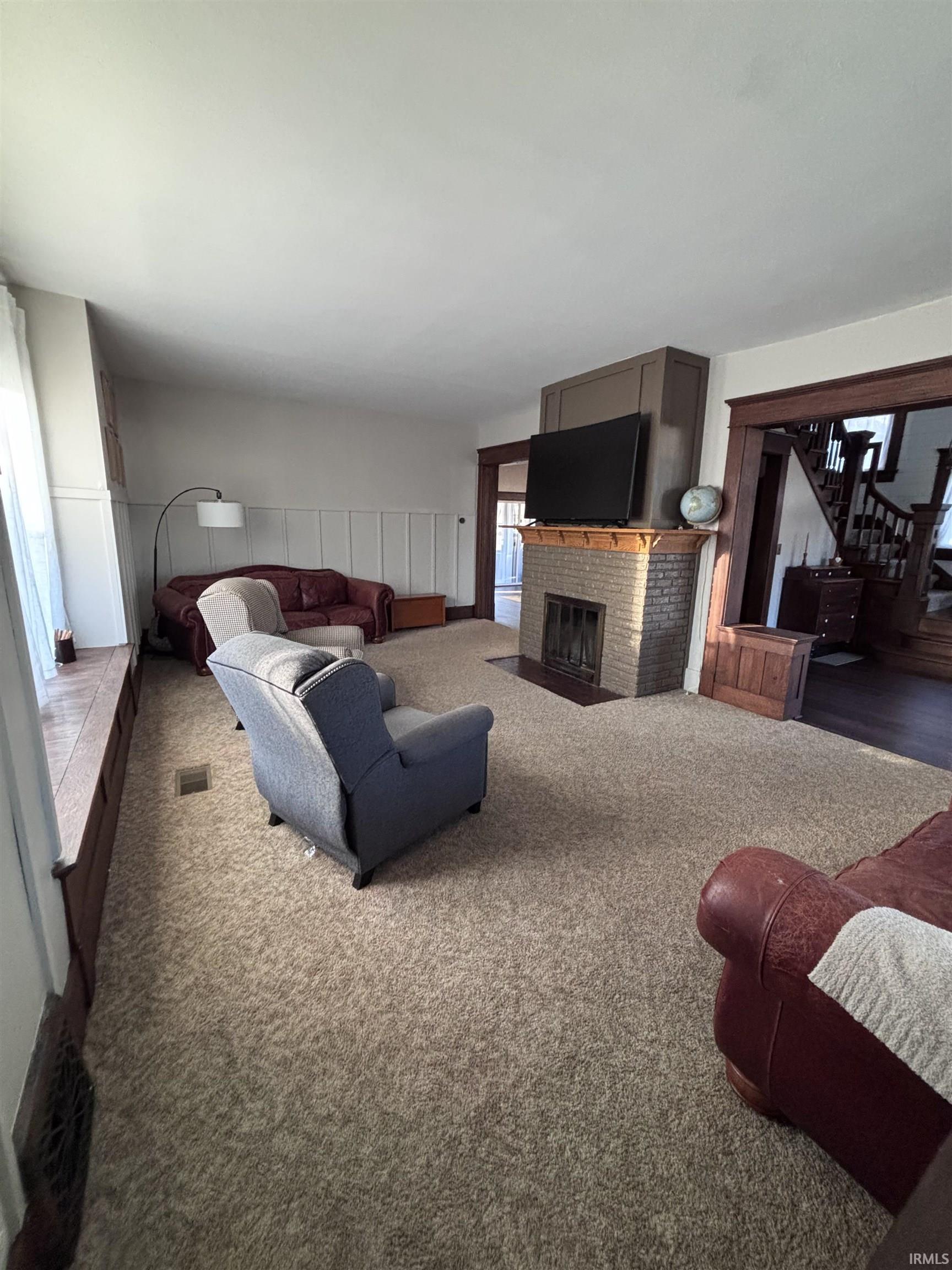 Carpeted living area with a wood burning fireplace