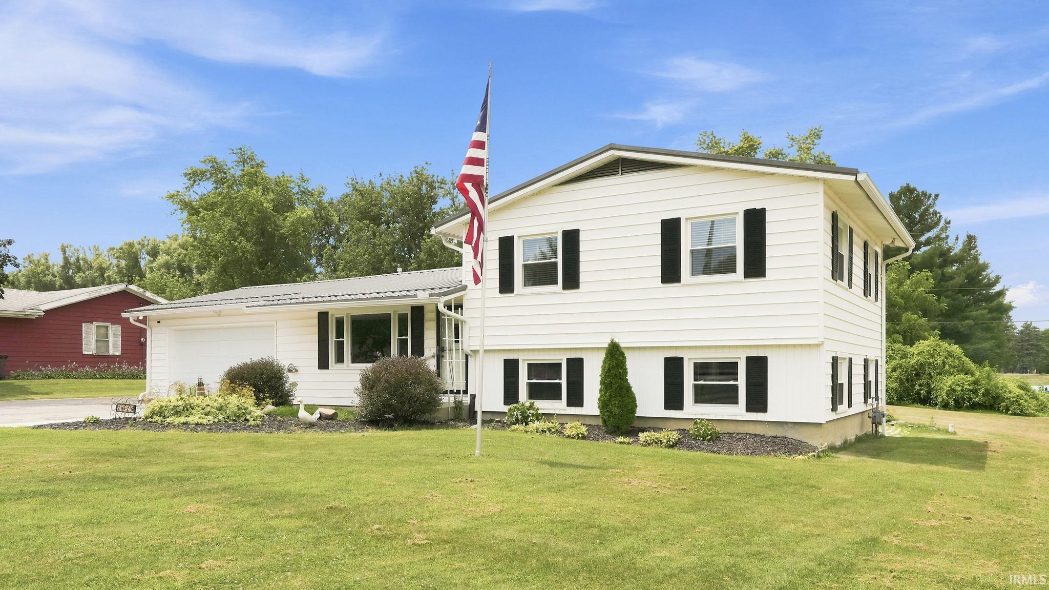 White exterior with black shutters and a two-car garage