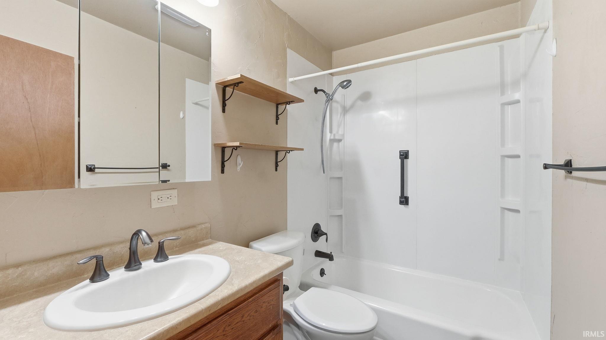 Bathroom featuring a vanity with a drop-in sink, dark bronze faucet, and medicine cabinet