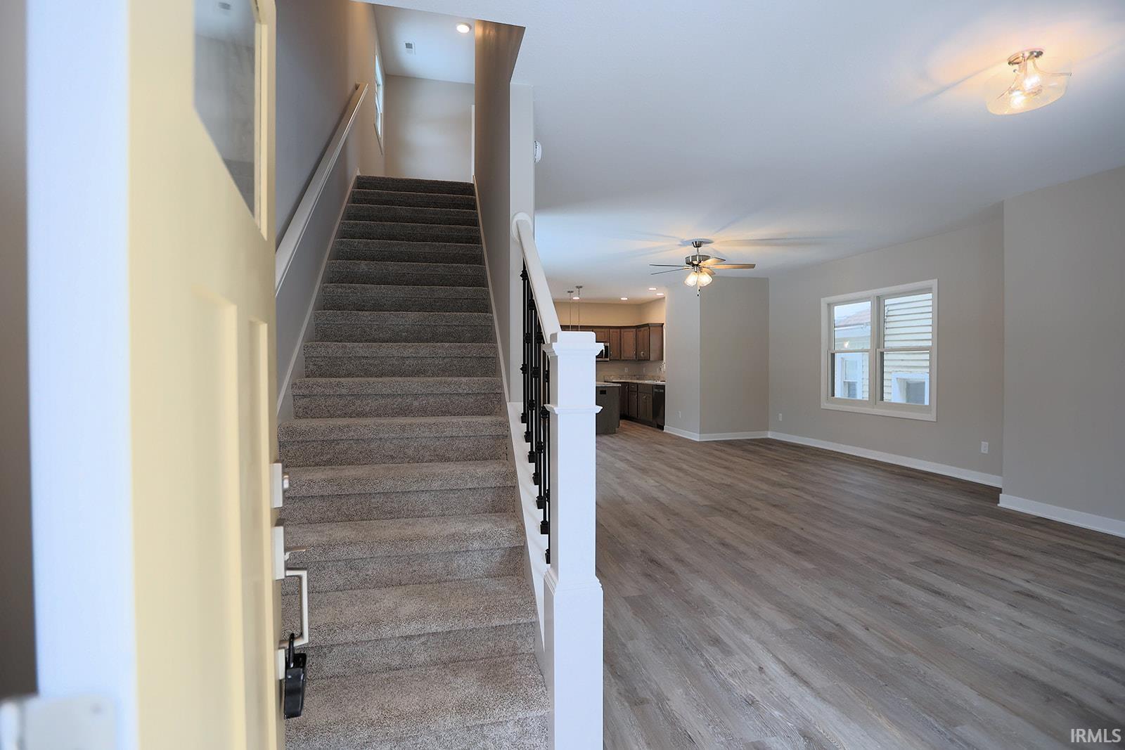 Staircase with recessed lighting, wood finished floors, and a ceiling fan