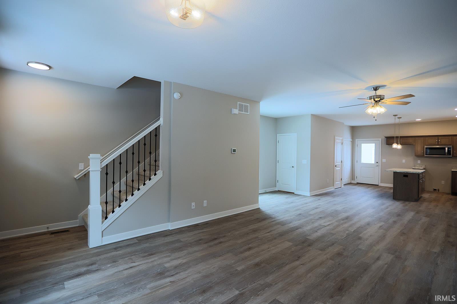 Unfurnished living room with recessed lighting, dark wood-type flooring, and ceiling fan