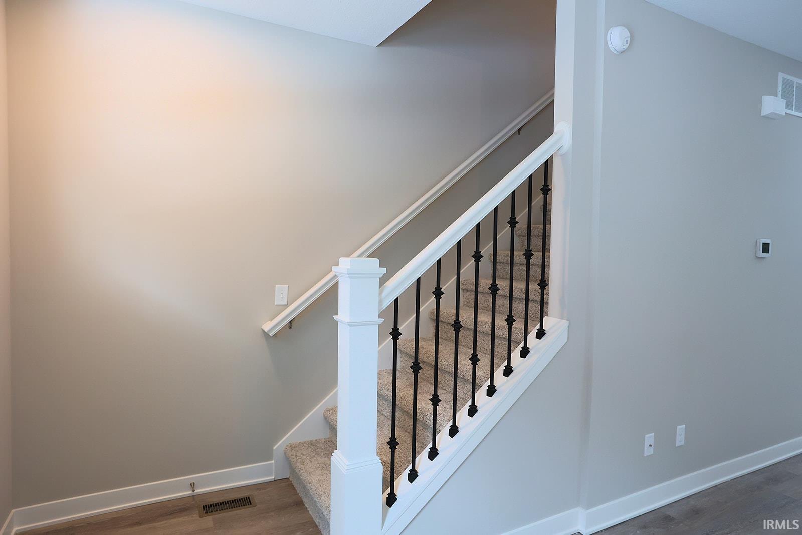 Stairs featuring wood finished floors