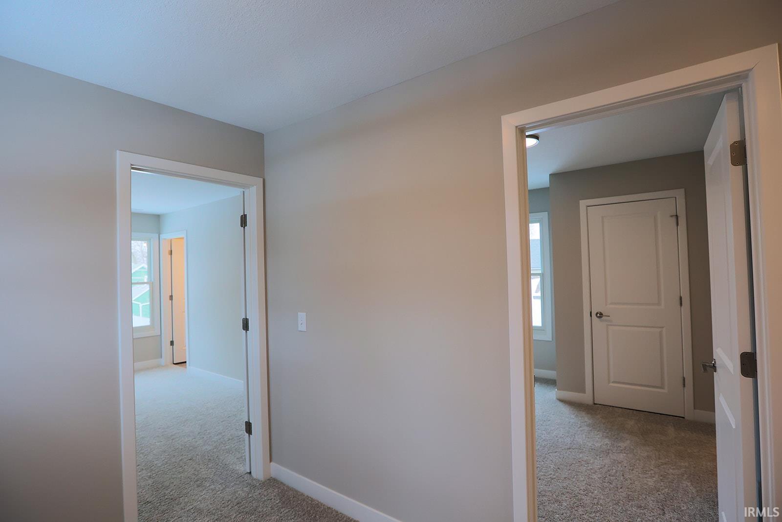 Hallway featuring light colored carpet