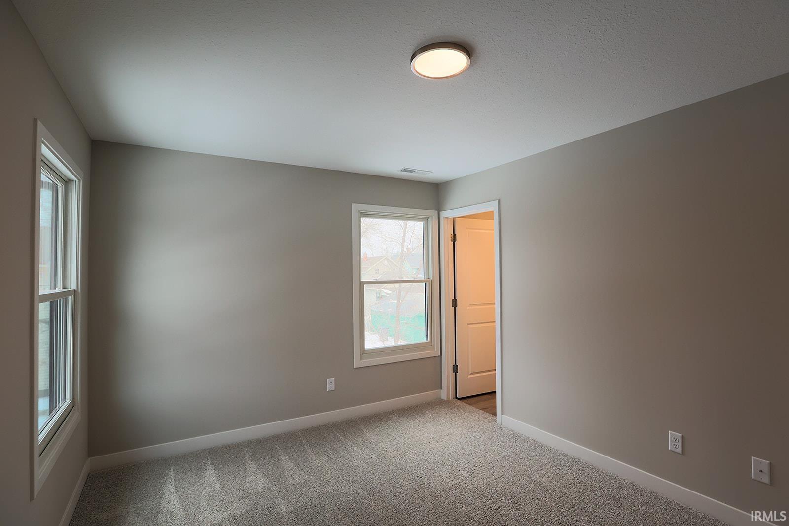 Empty room featuring carpet and baseboards