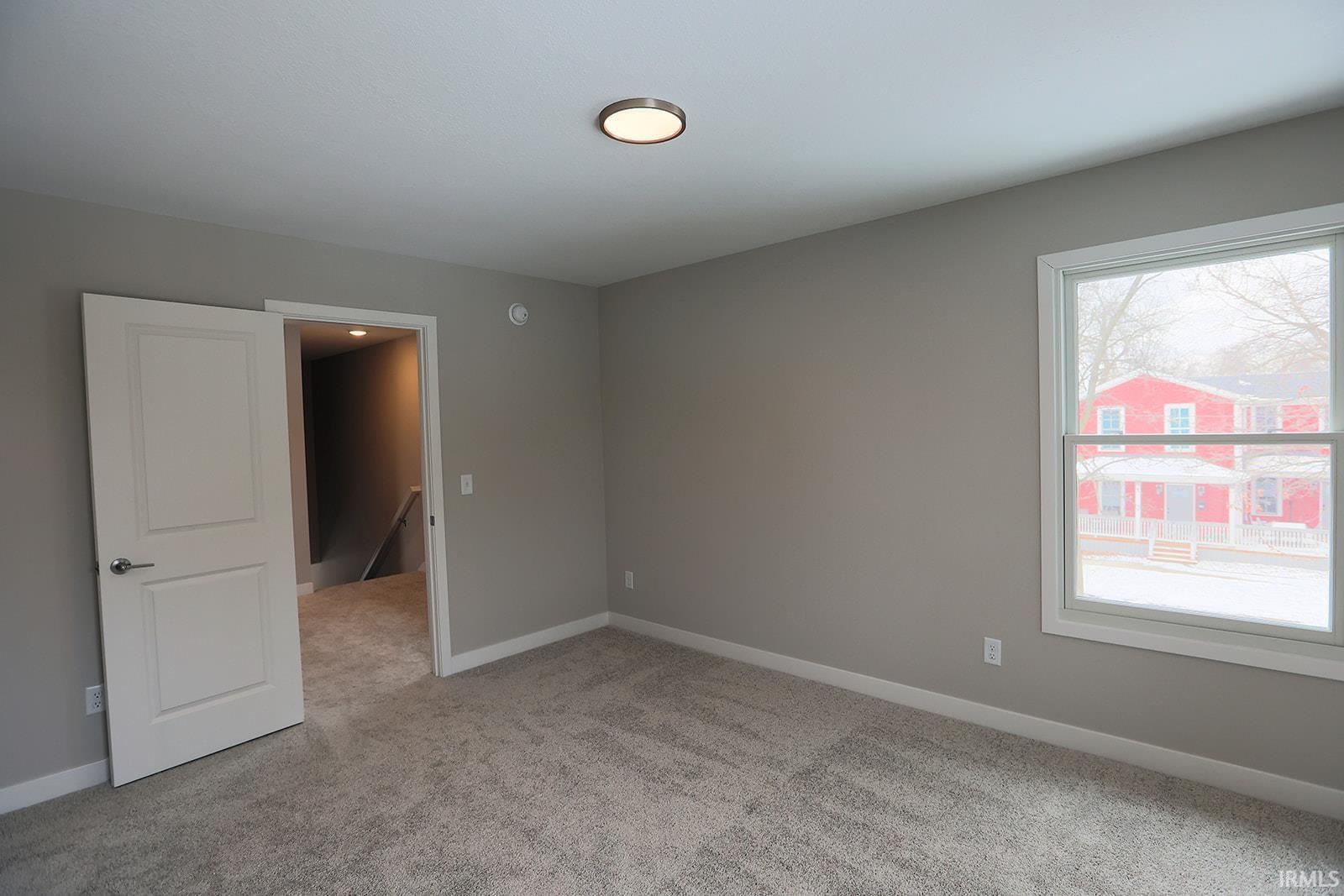 Empty room featuring light carpet and baseboards