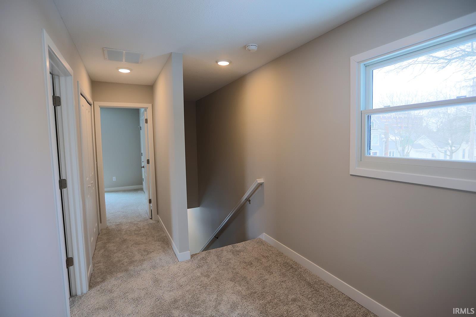 Corridor featuring an upstairs landing, carpet floors, and recessed lighting