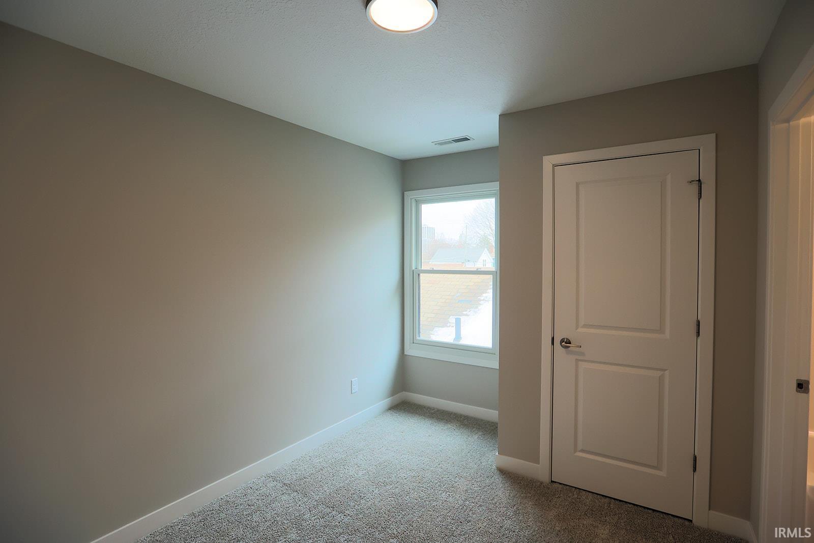 Unfurnished bedroom featuring carpet and baseboards