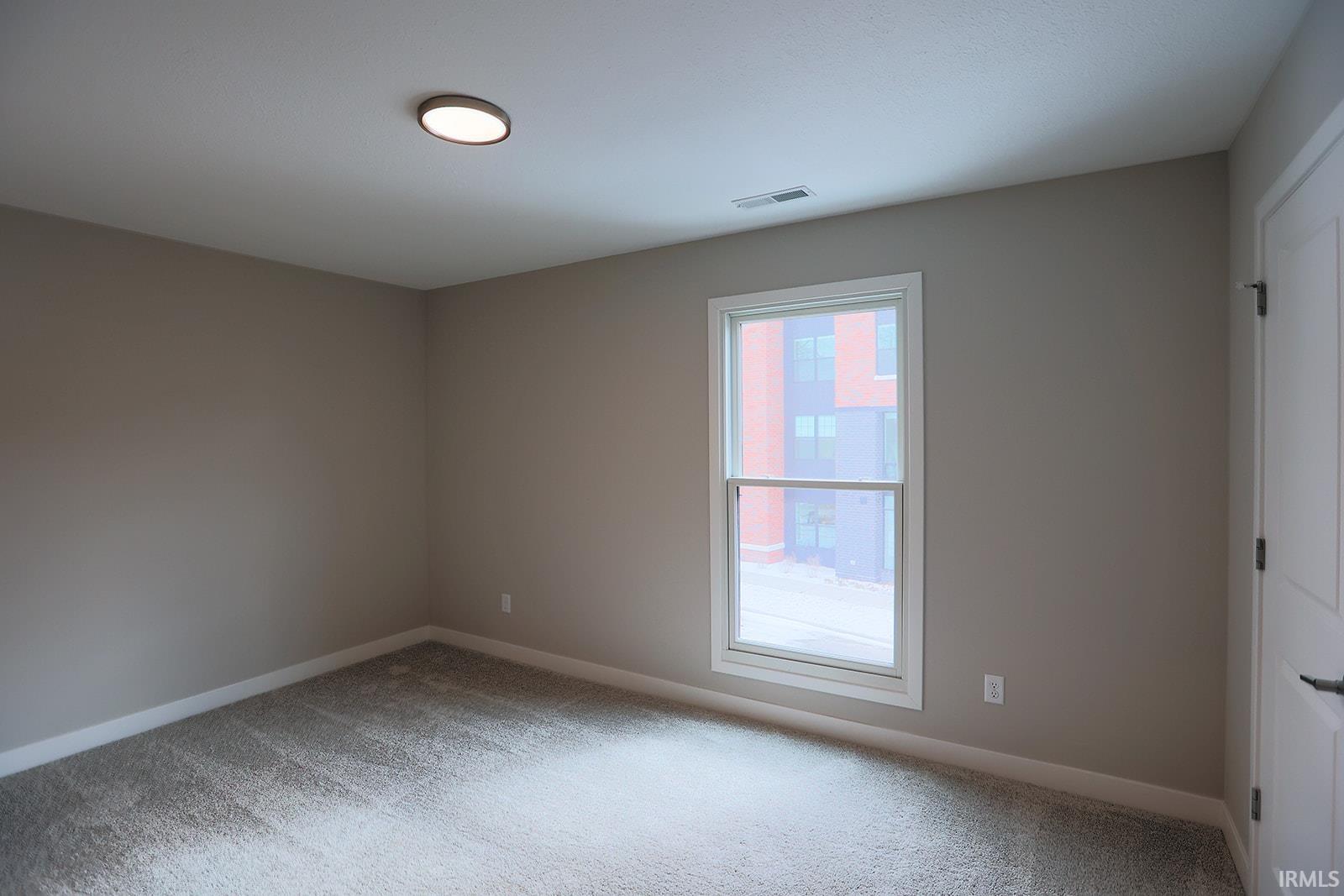 Unfurnished room featuring light colored carpet and baseboards