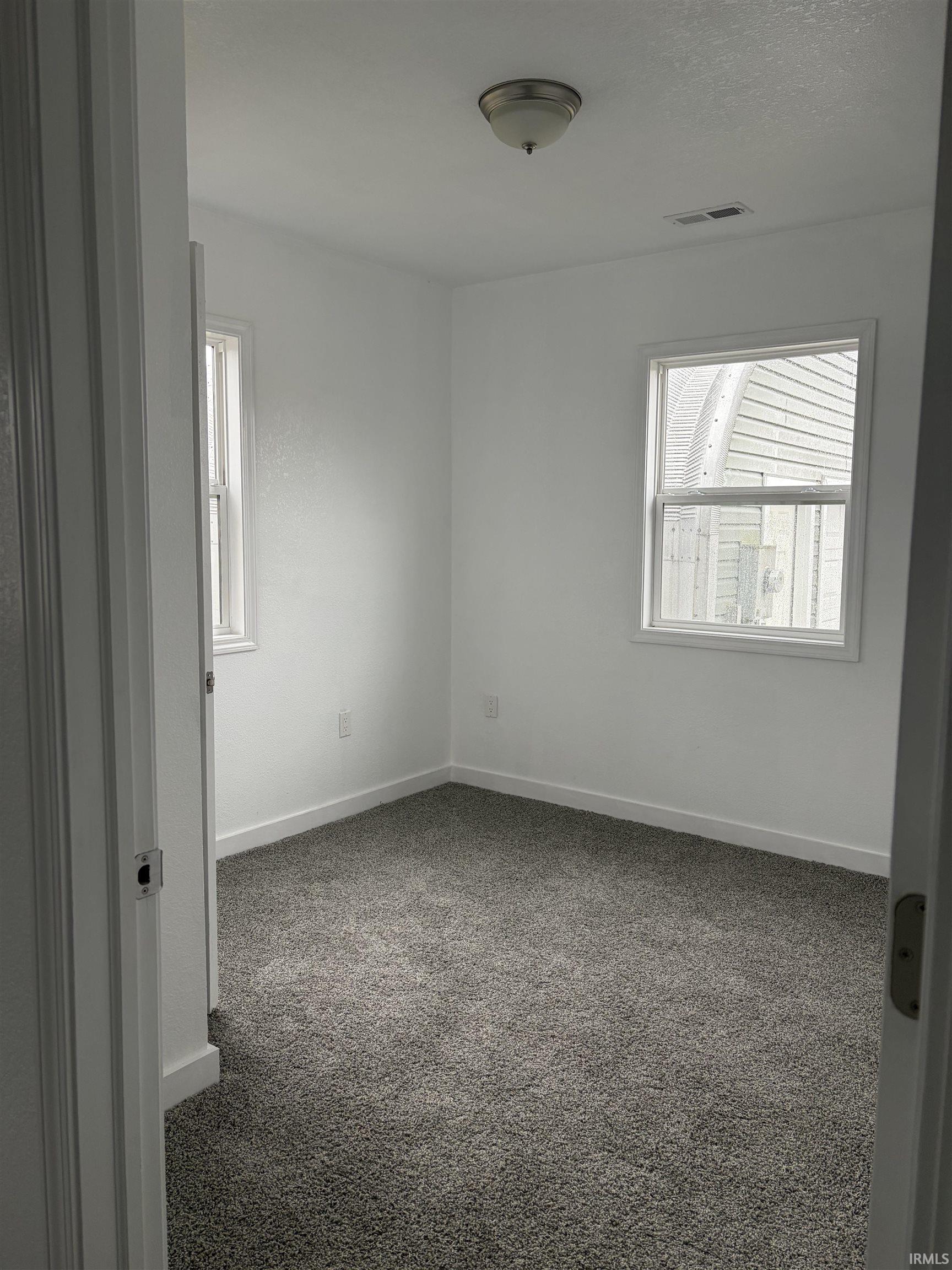 Spare room featuring carpet and baseboards