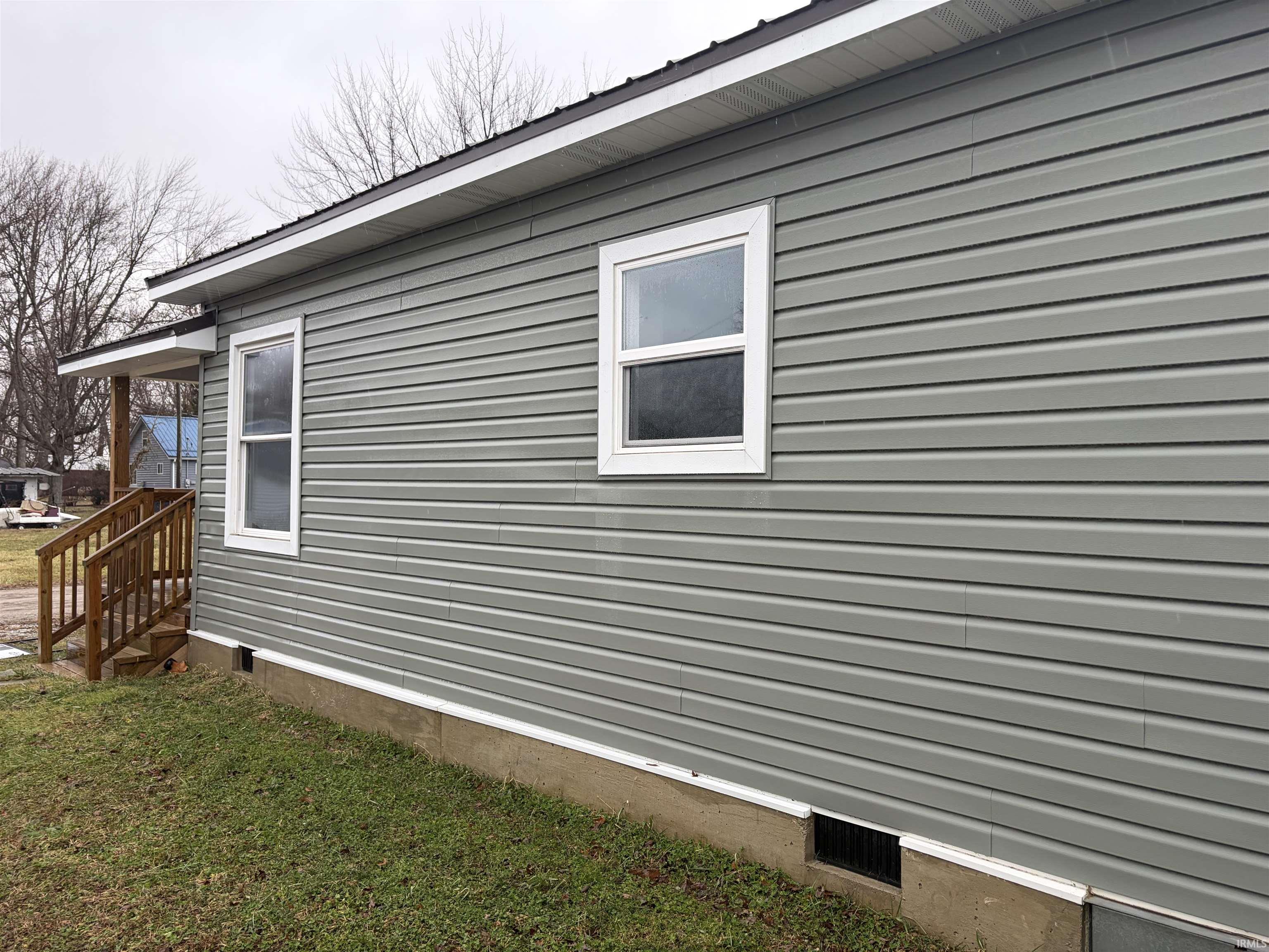 View of side of property with crawl space and a yard
