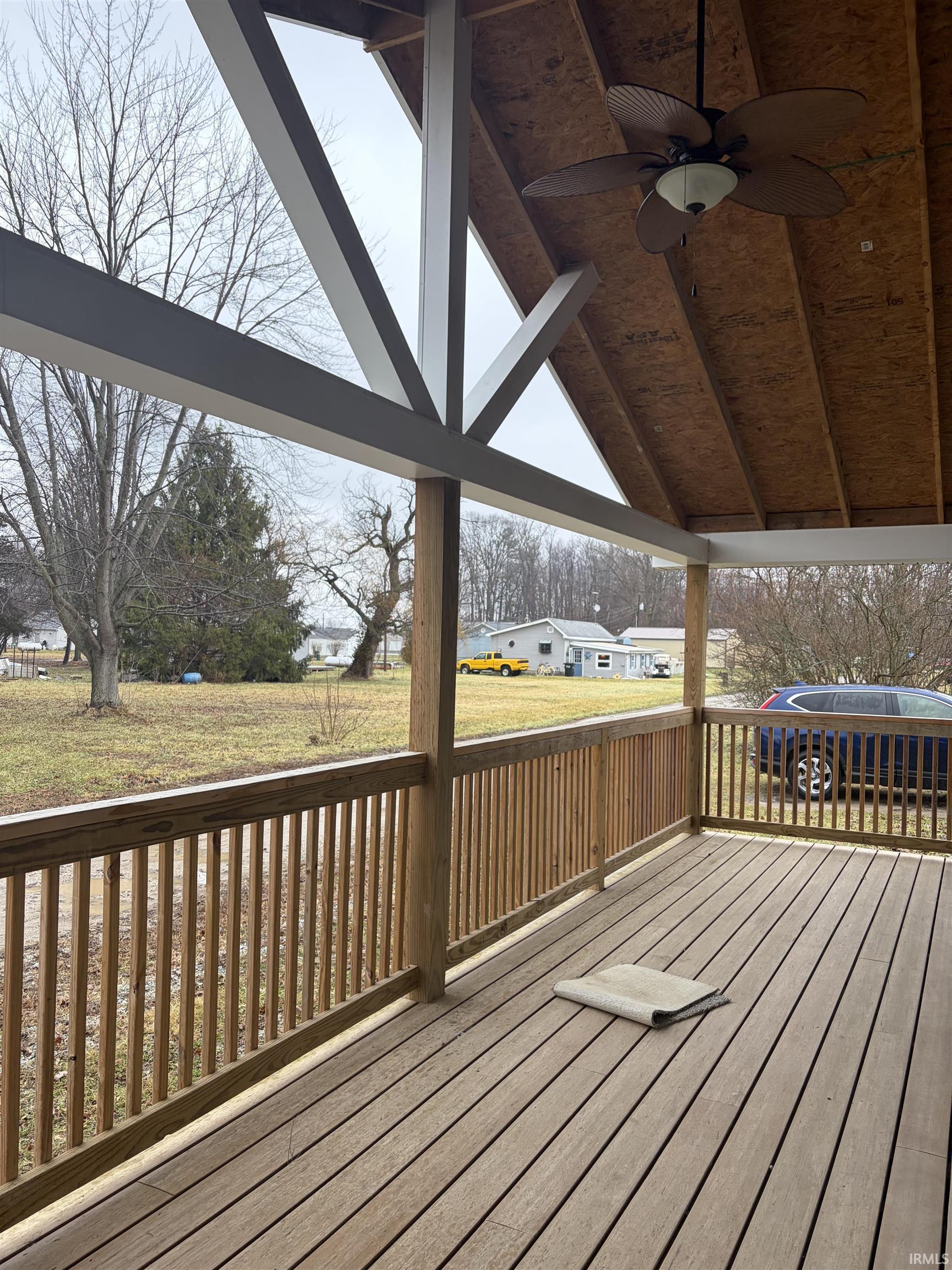 Wooden deck with a ceiling fan and a lawn