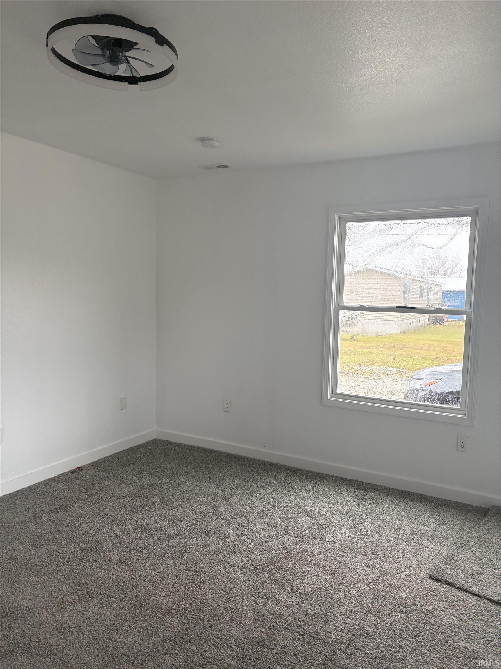 Carpeted empty room featuring baseboards