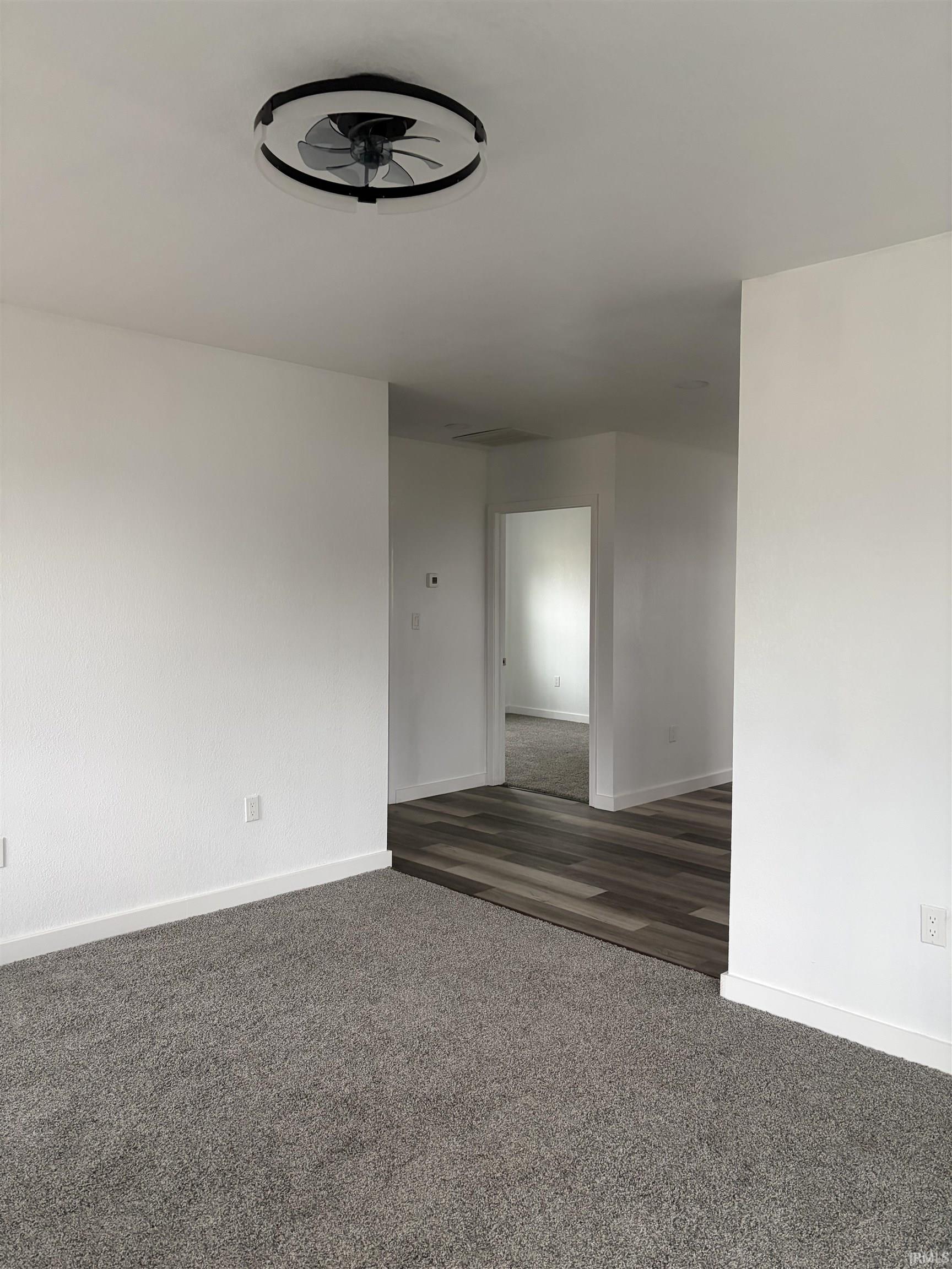 Spare room featuring dark colored carpet