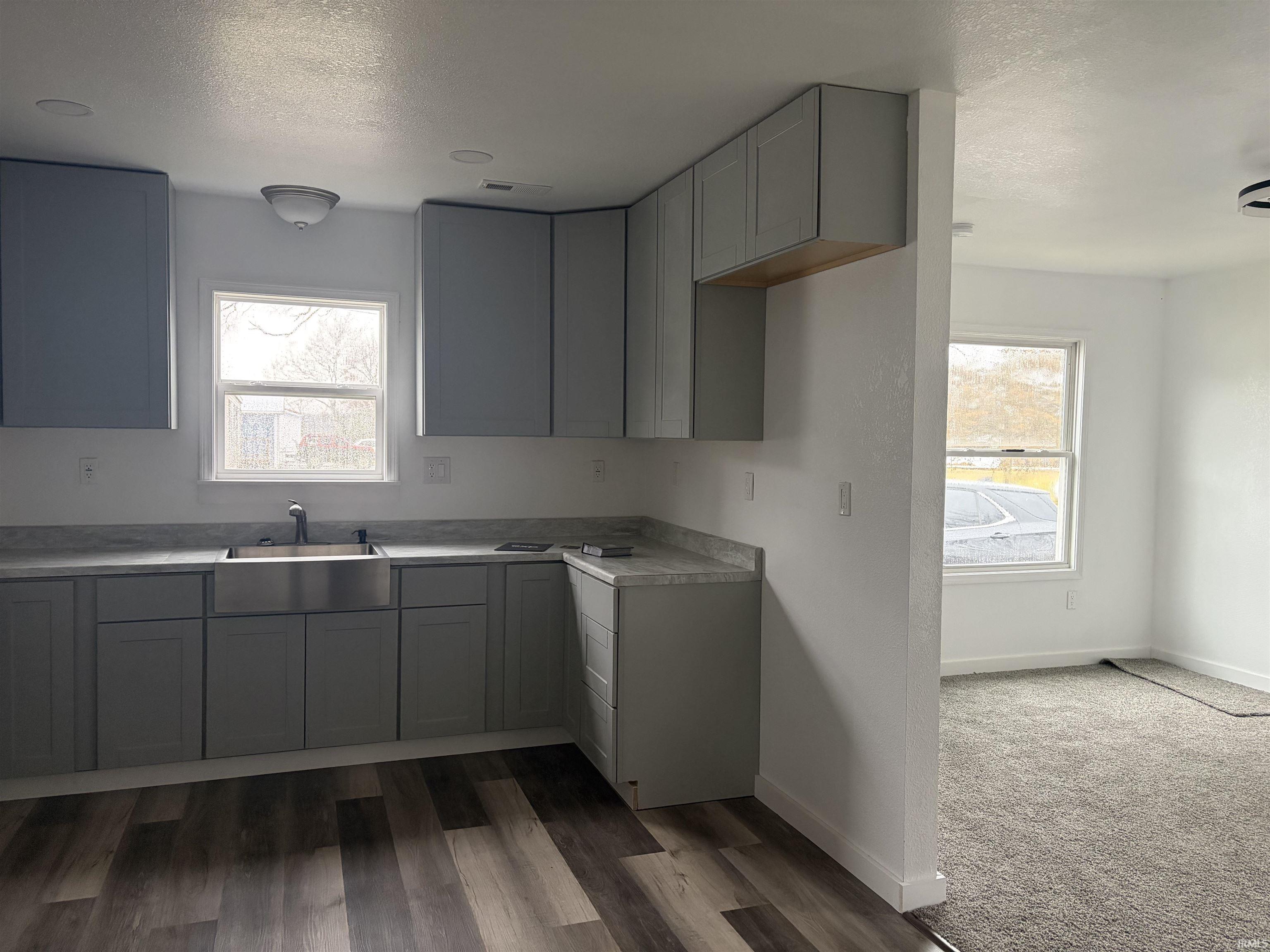 Kitchen featuring gray cabinetry, plenty of natural light, light countertops, and a textured ceiling