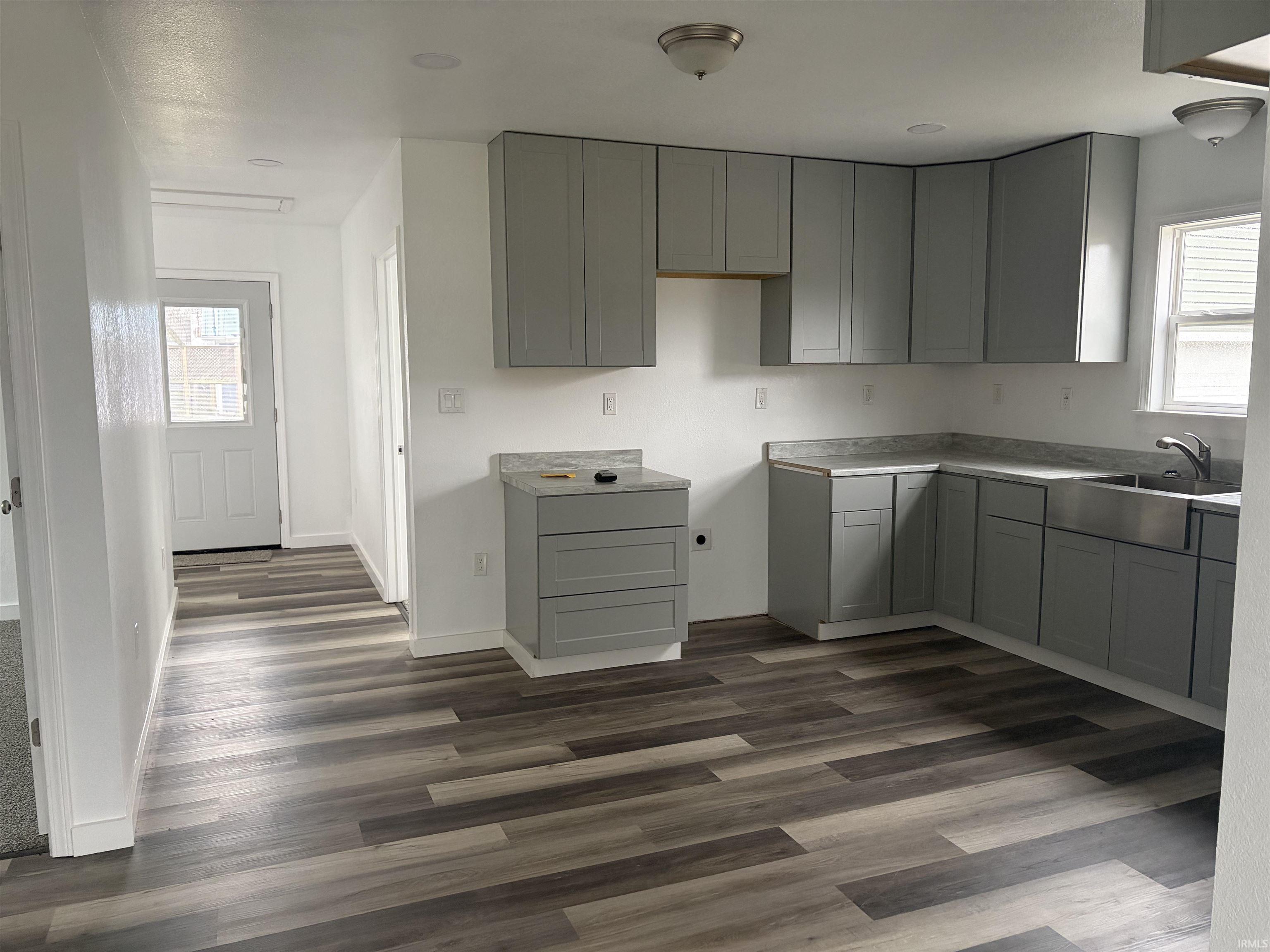 Kitchen with plenty of natural light, gray cabinetry, and light countertops