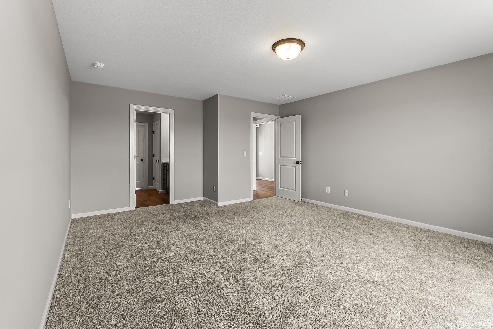 Unfurnished bedroom with carpet floors and ensuite bath