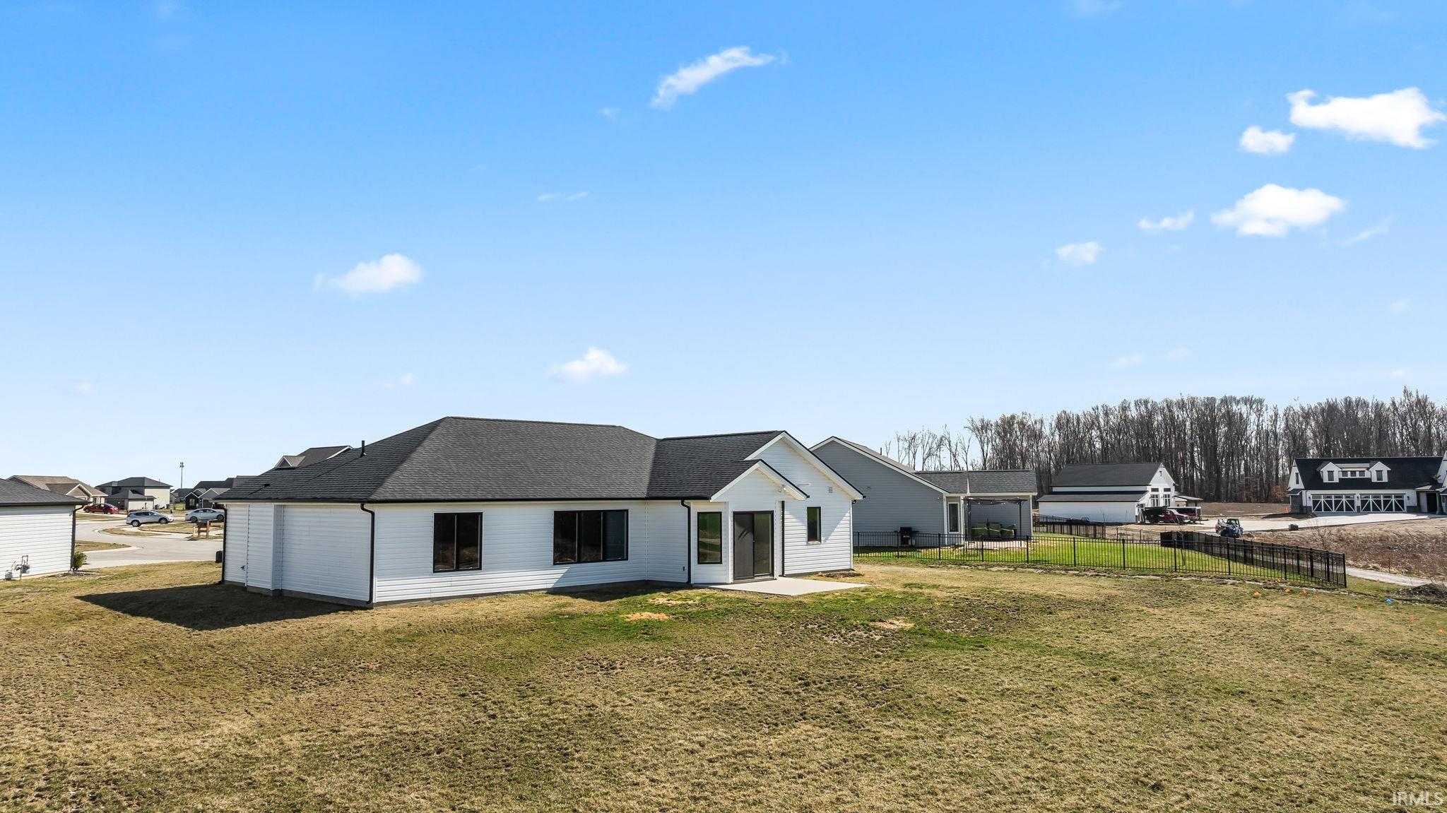 Back of house with a patio area and roof with shingles