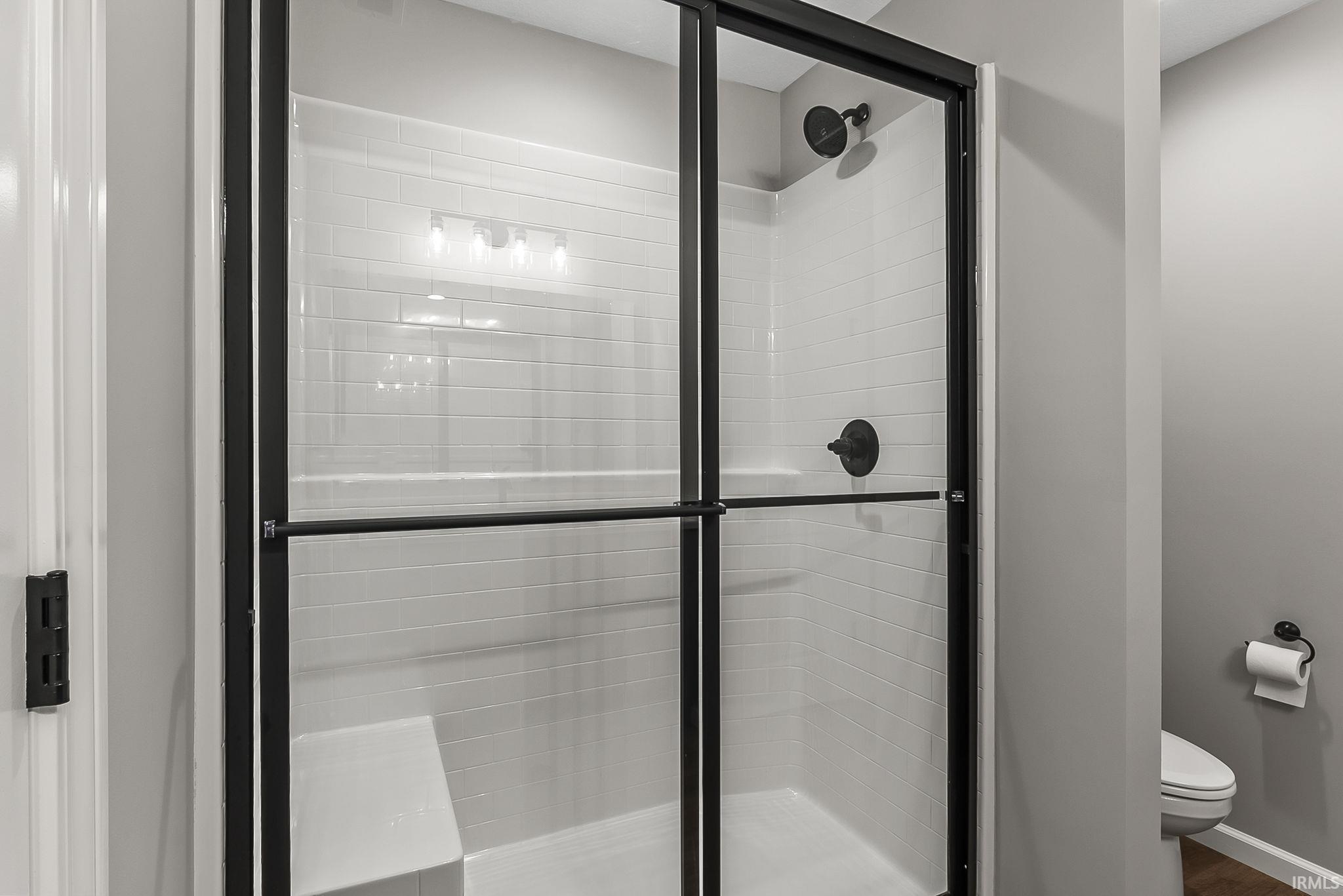 Full bath featuring a stall shower and toilet