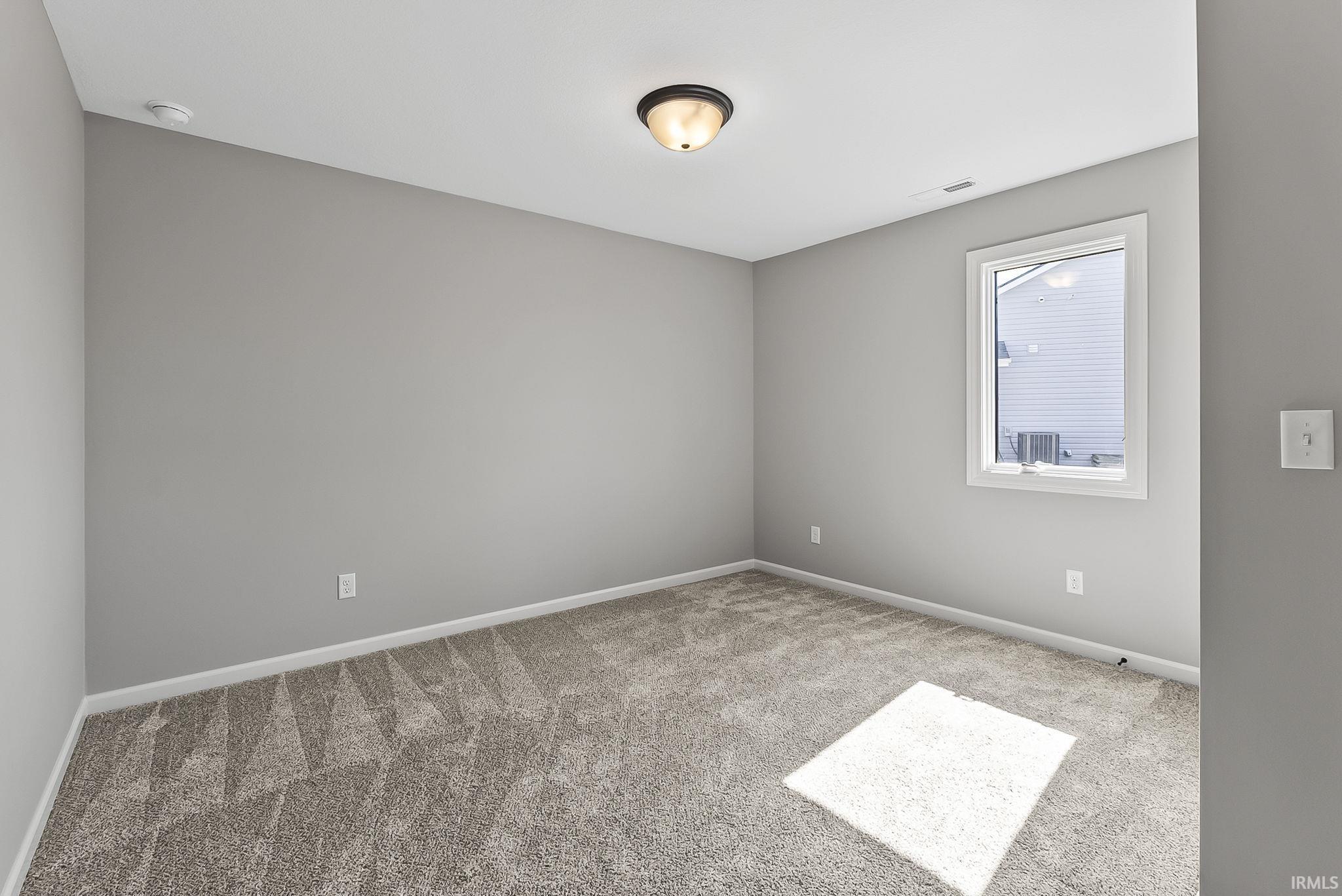 Carpeted empty room featuring baseboards