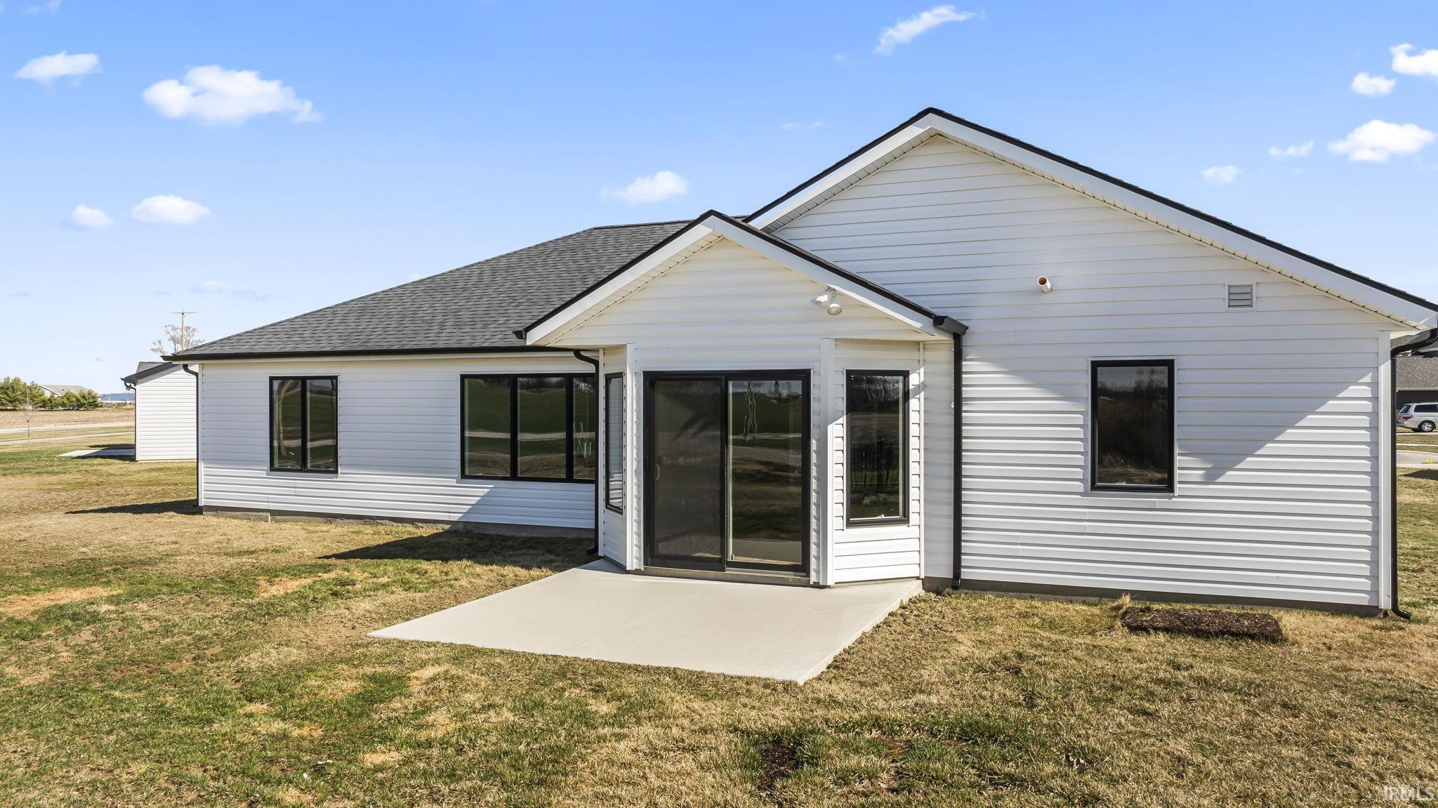 Rear view of property with a yard and a shingled roof