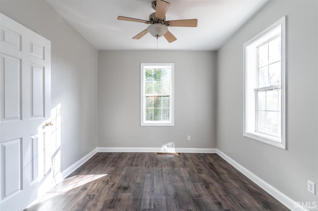 Spare room featuring a ceiling fan and dark wood-style floors