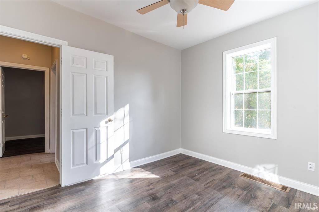 Unfurnished room with ceiling fan and dark wood-style floors